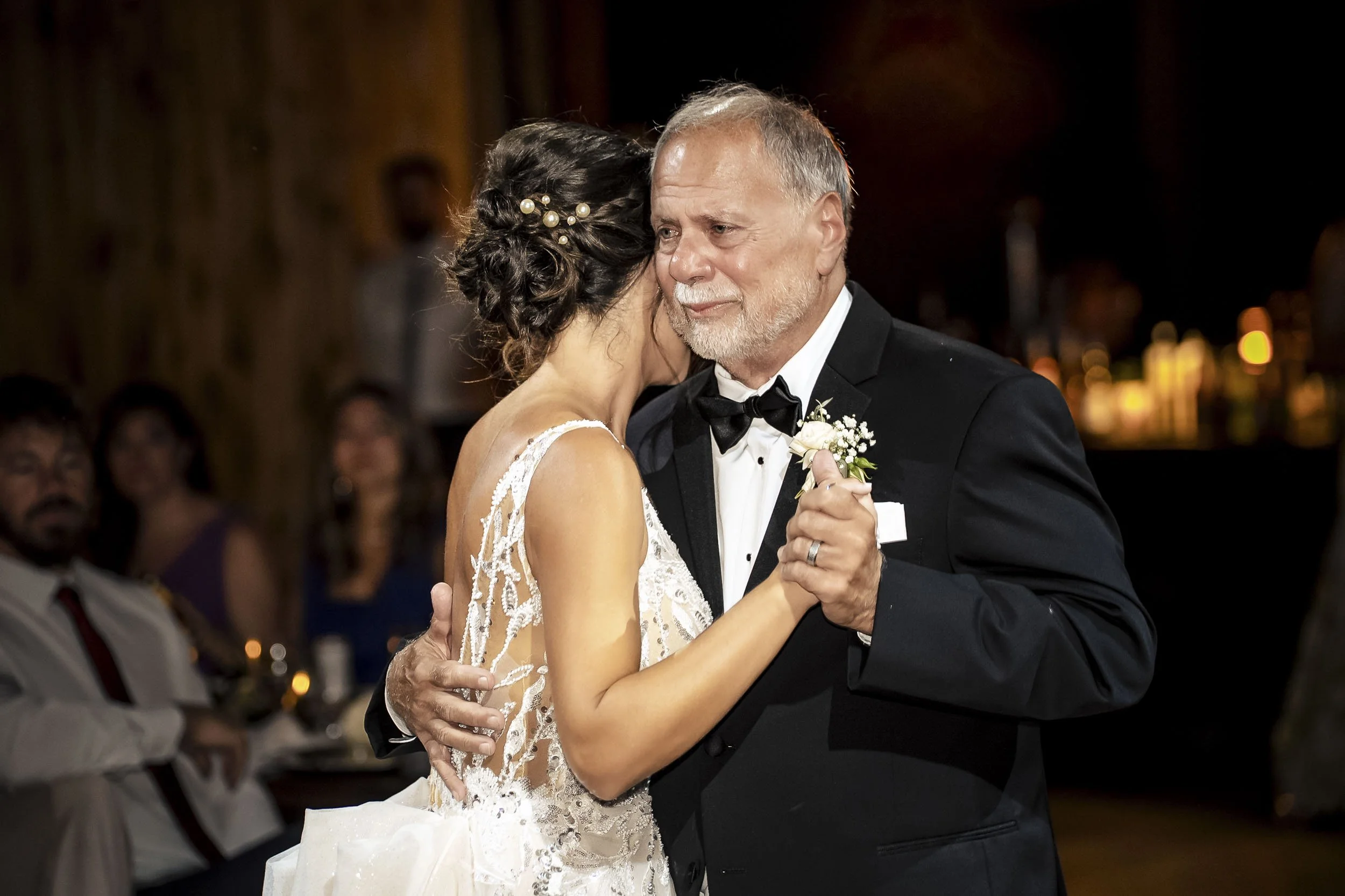 Sarah dancing closely with her father, whose emotional expression is visible over her shoulder.