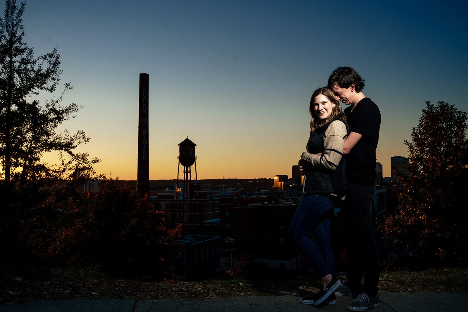 Aly and Chris holding hands in silhouette against the evening sky in Richmond