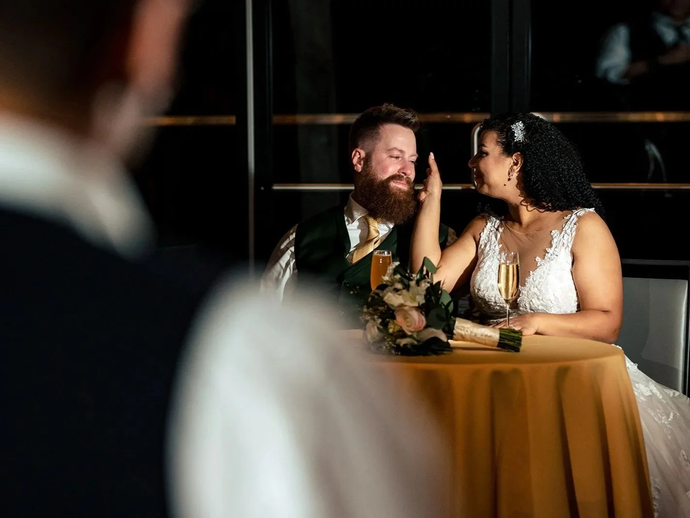 bride wiping tear off groom during best man speech