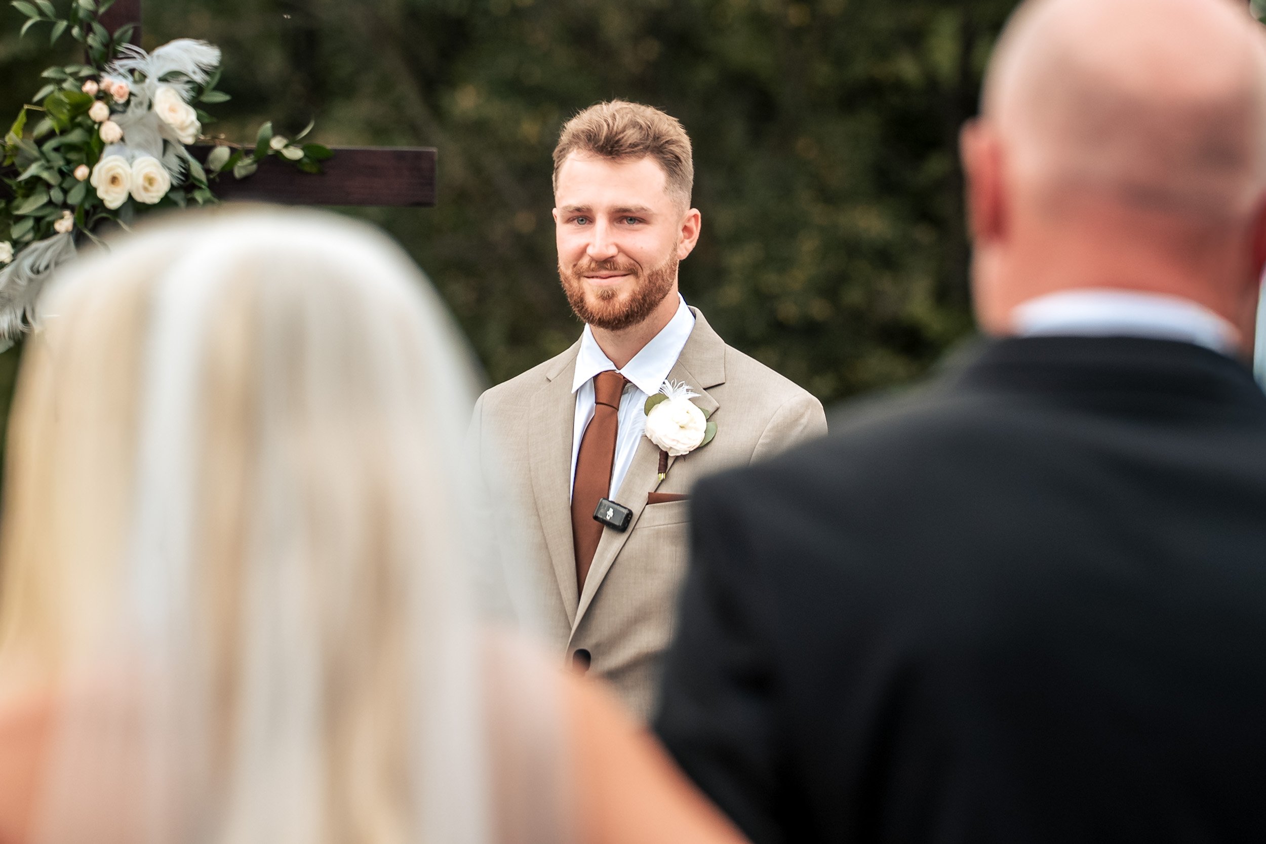 Jacob smiles toward Ava during their outdoor wedding ceremony.