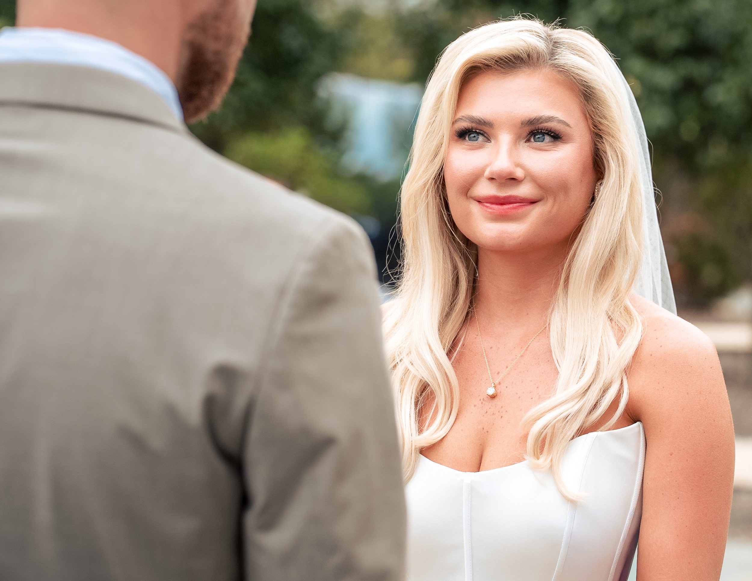 Ava looks toward Jacob during their outdoor wedding ceremony.