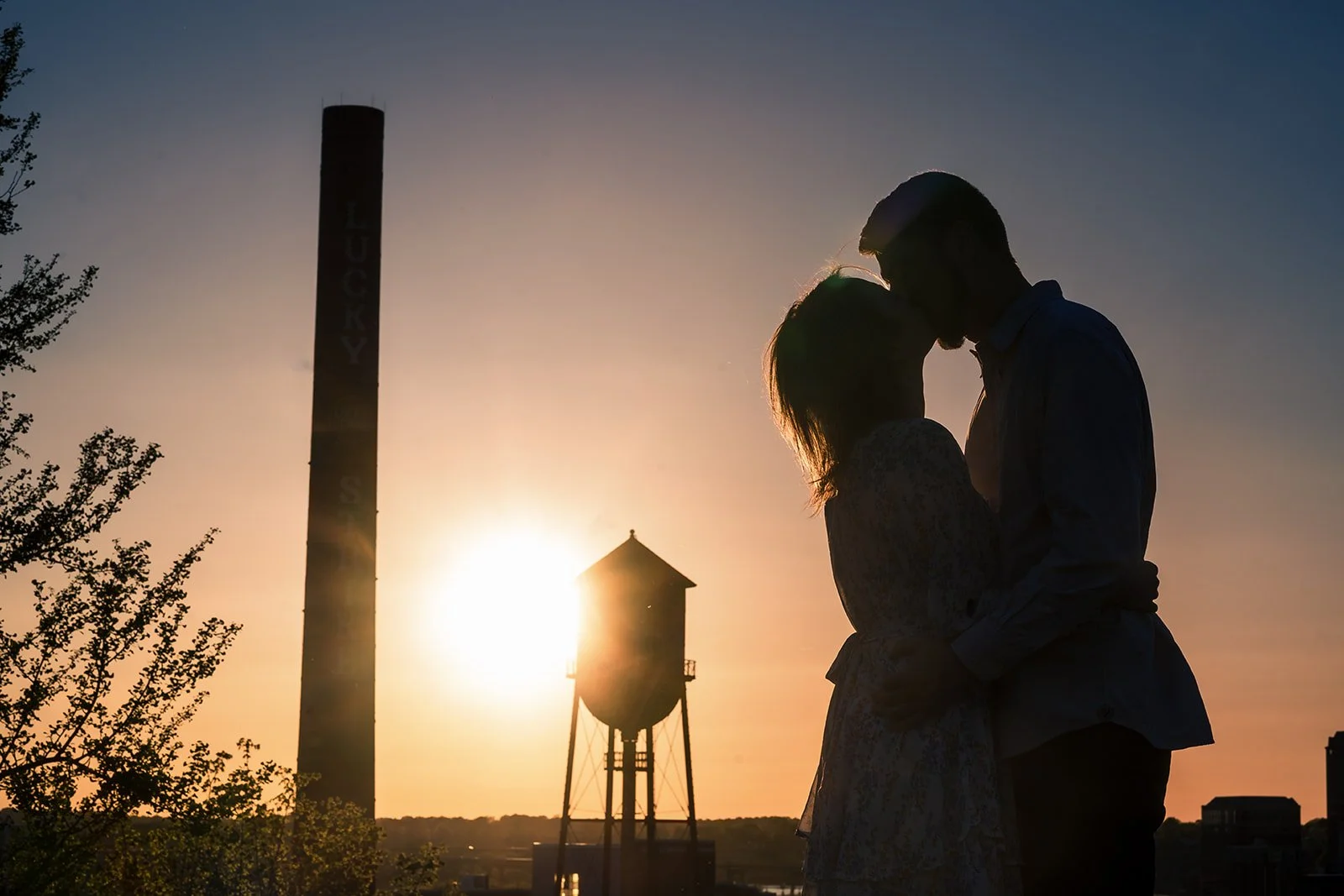 Natasha and Bryan embracing in silhouette during an April sunset in Richmond