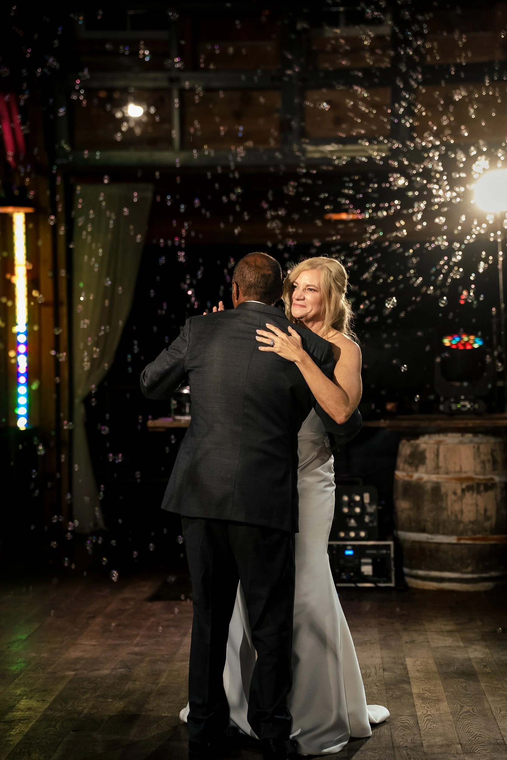 bride and groom first dance with bubbles behind them