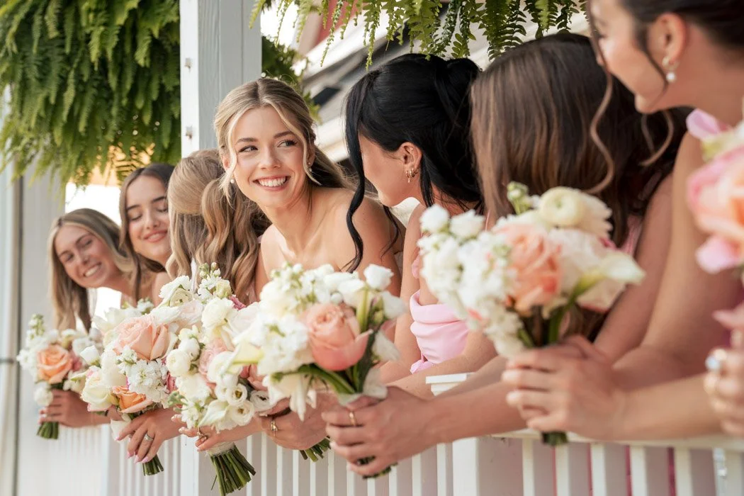 Fiona laughing with her bridesmaids in soft pink dresses before her Manassas wedding.`