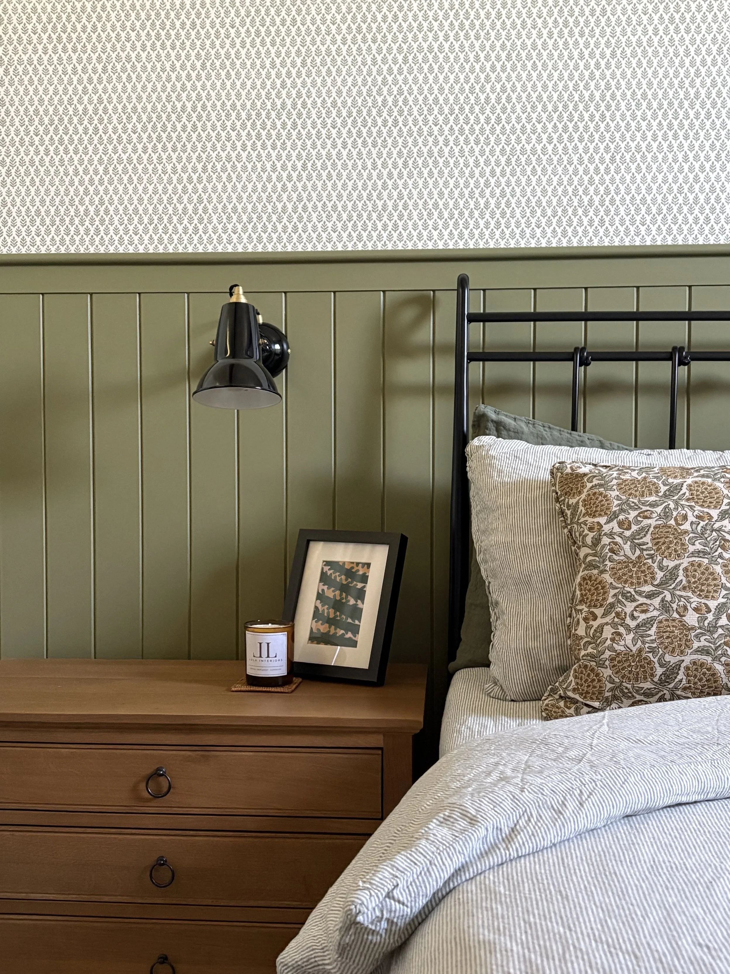 Tongue and groove panelling detail behind bed in a charming cottage bedroom interior