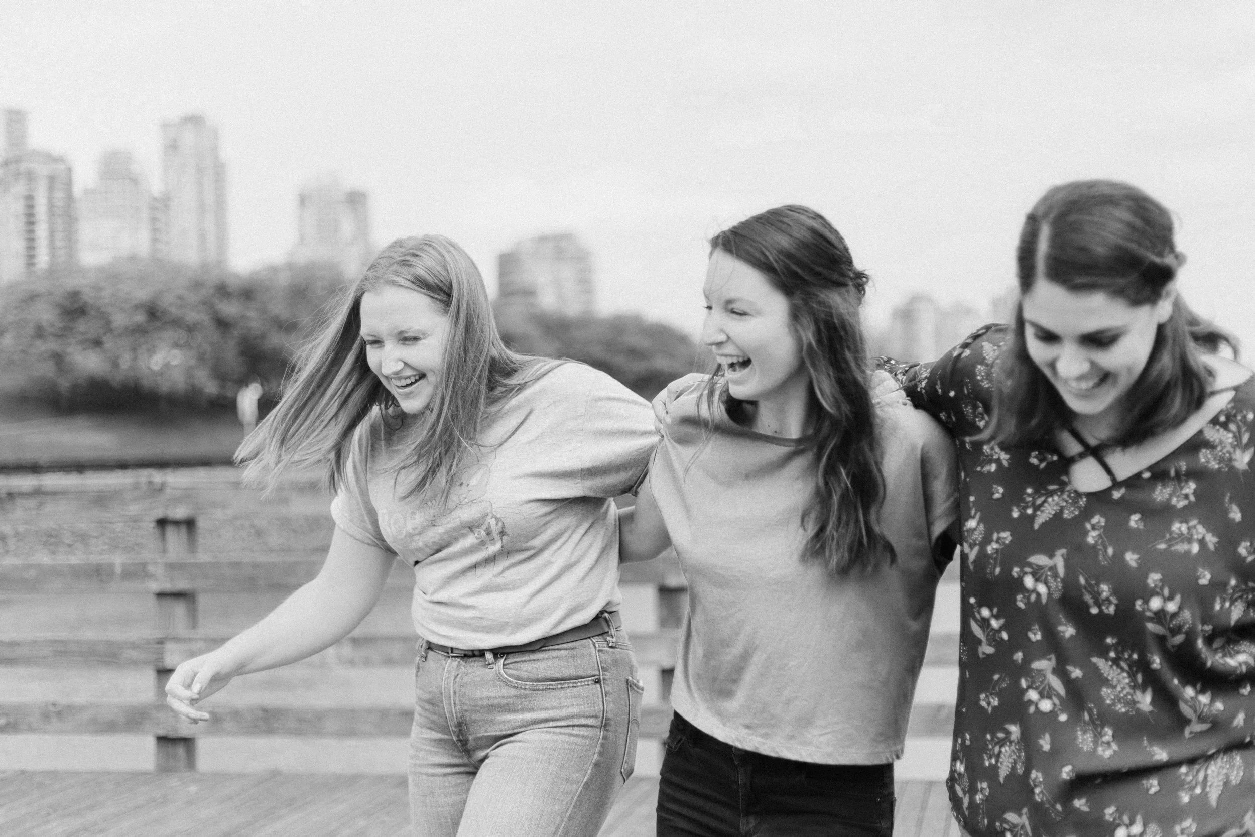 Two women enjoying a supportive connection in a local park, illustrating the goal of mental health evaluations: to help clients thrive in their relationships and community.
