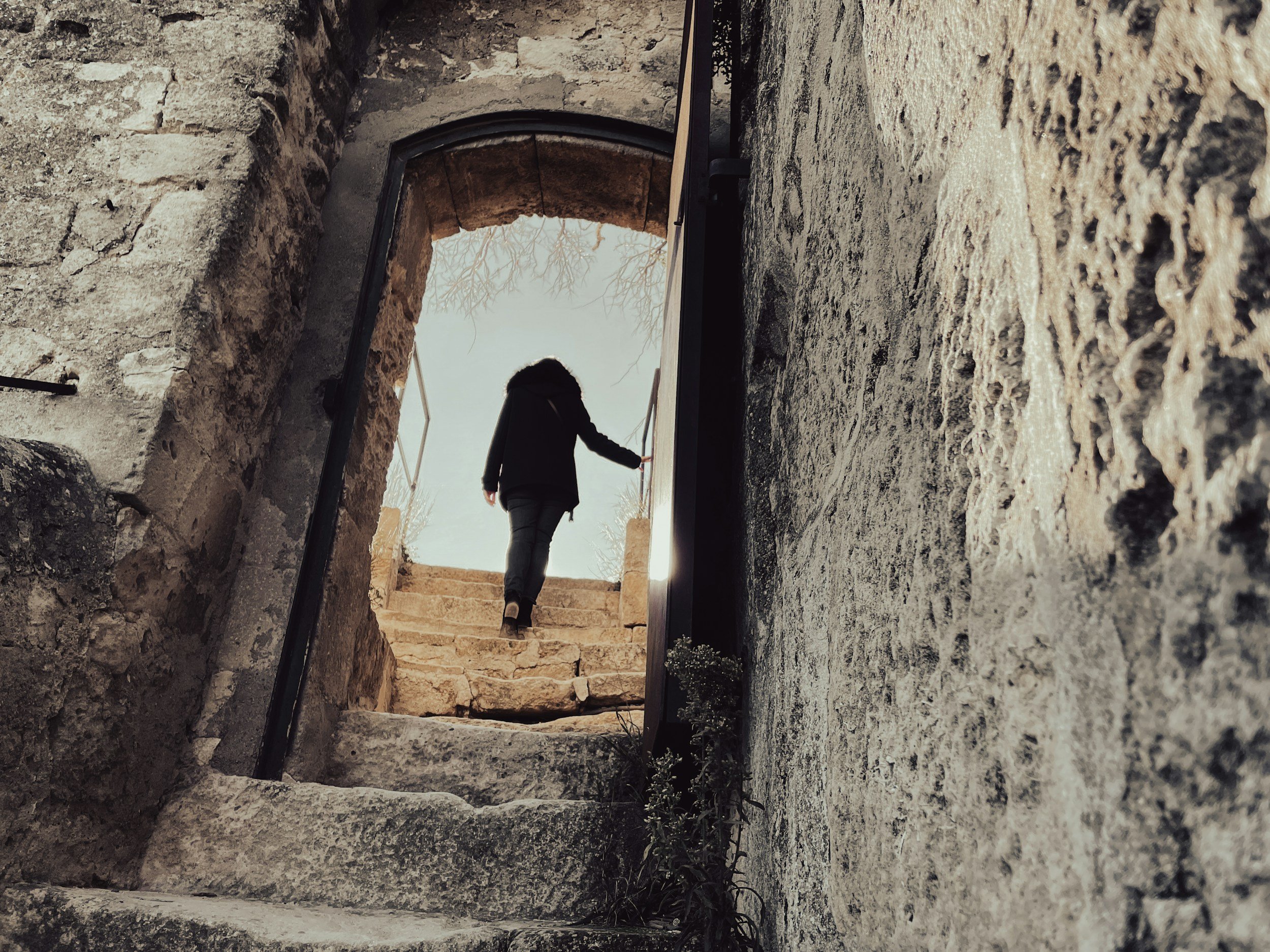 A person moving through a stone archway toward light, representing forward movement in the therapist search process for adults seeking ADHD support or therapy for therapists.