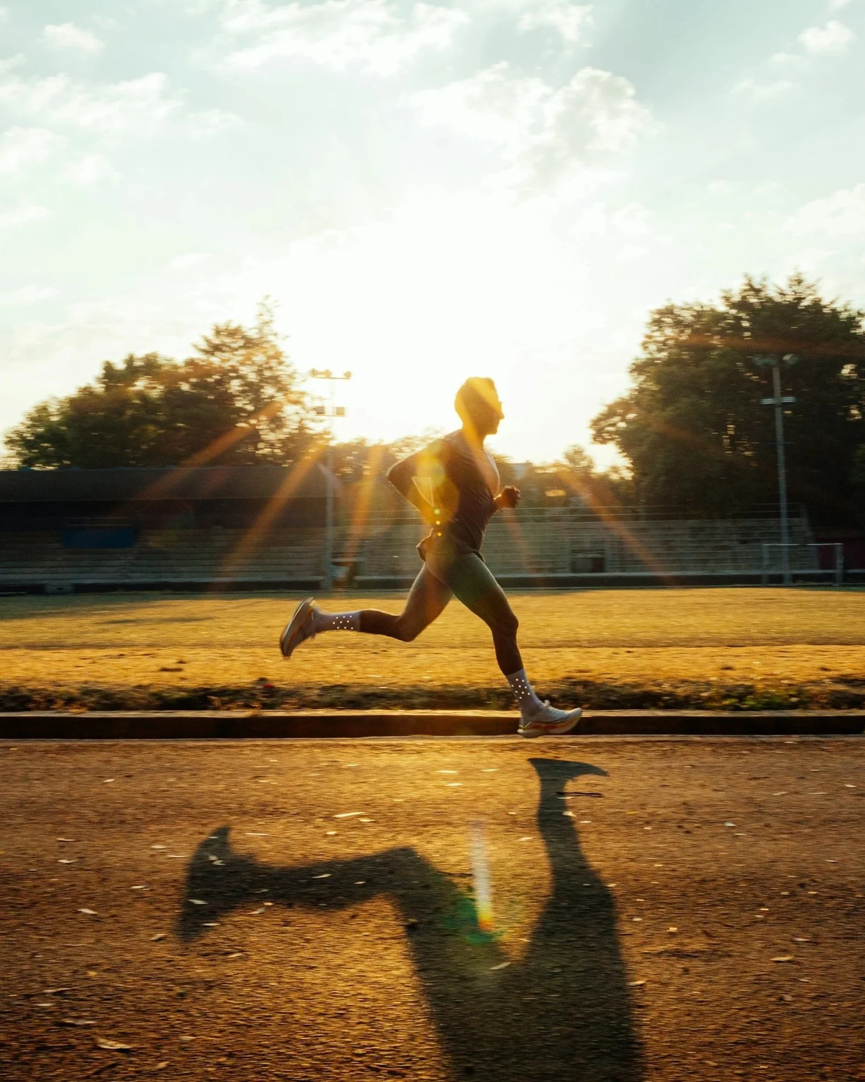 White man running while illuminated from behind by the sun.