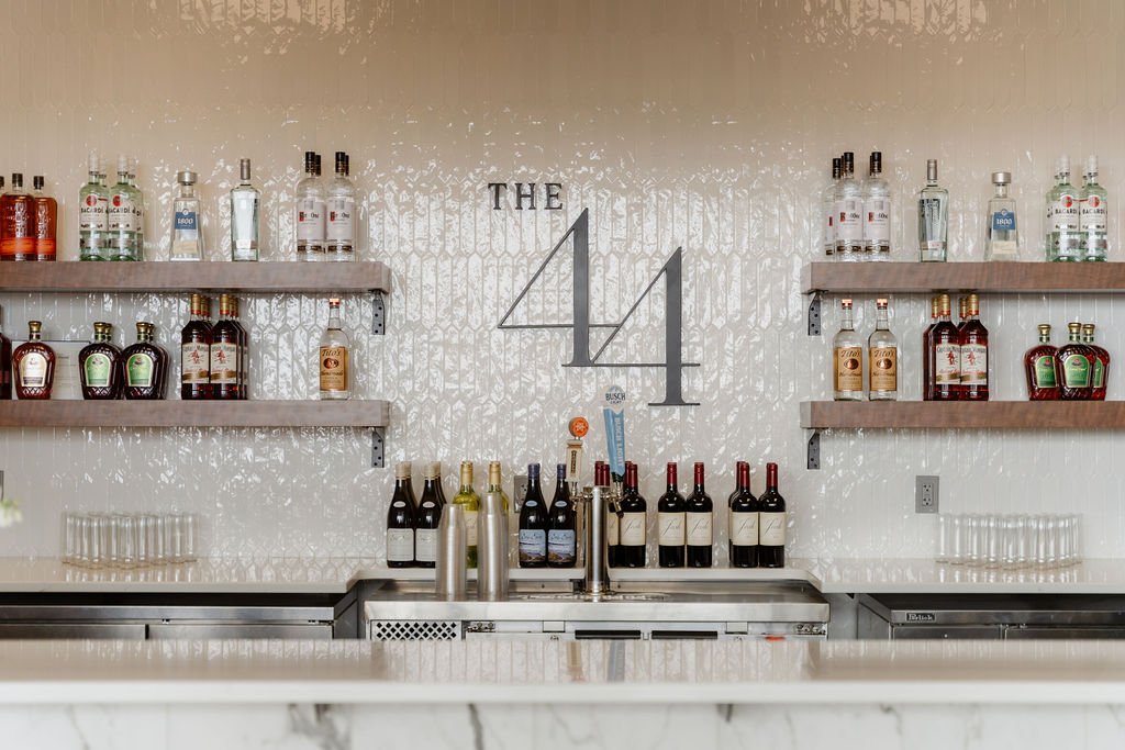 Bar area with shelves of liquor bottles and a large "THE 14" sign on the wall.
