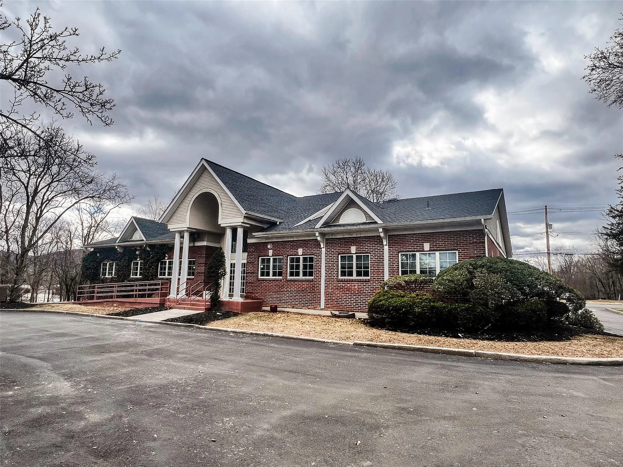 Brick building with arched entrance, cloudy sky