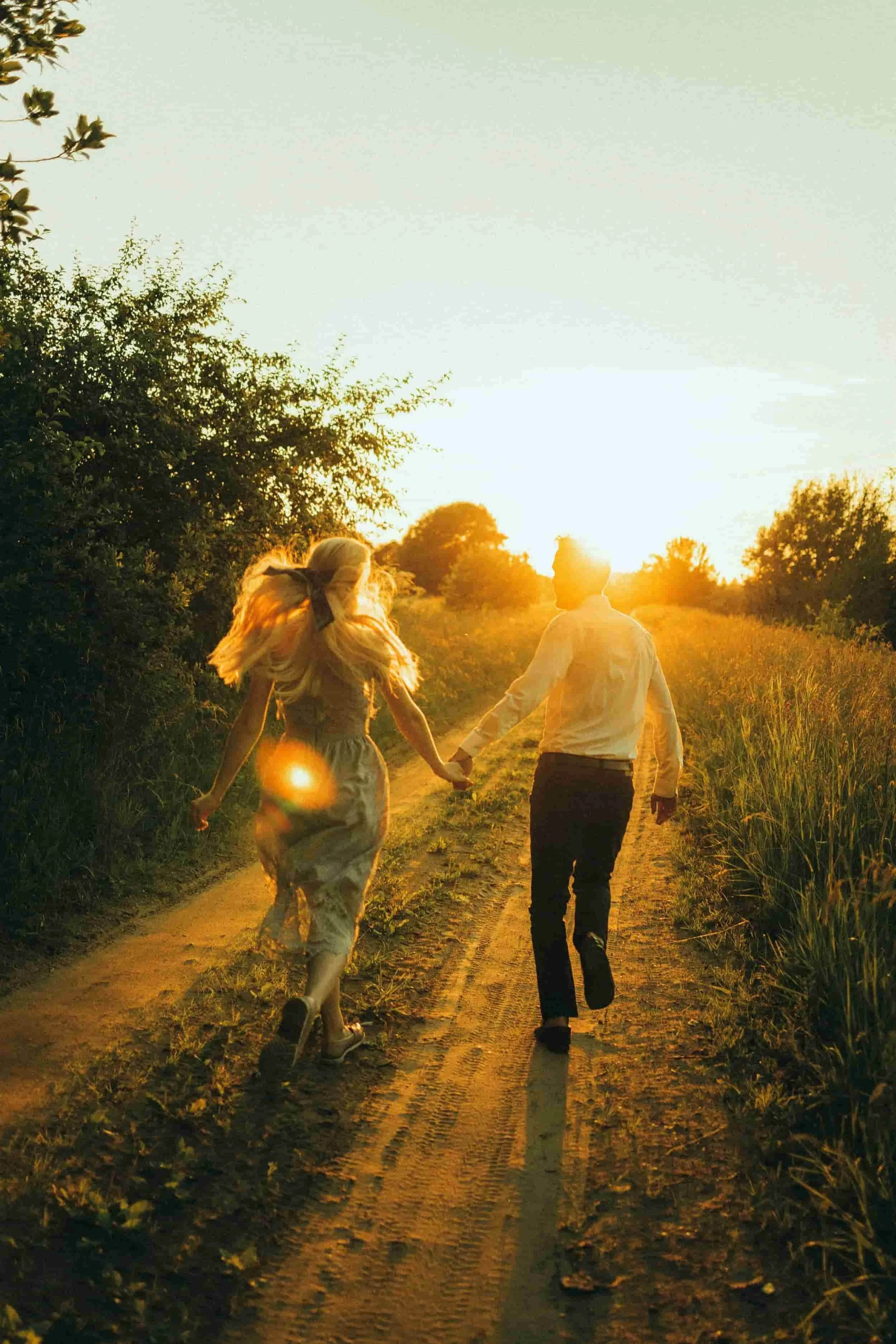 Couple holding hands while walking down a sunlit path, symbolizing secure attachment, relationship healing, and Christian counseling support for women and young adults in Texas.