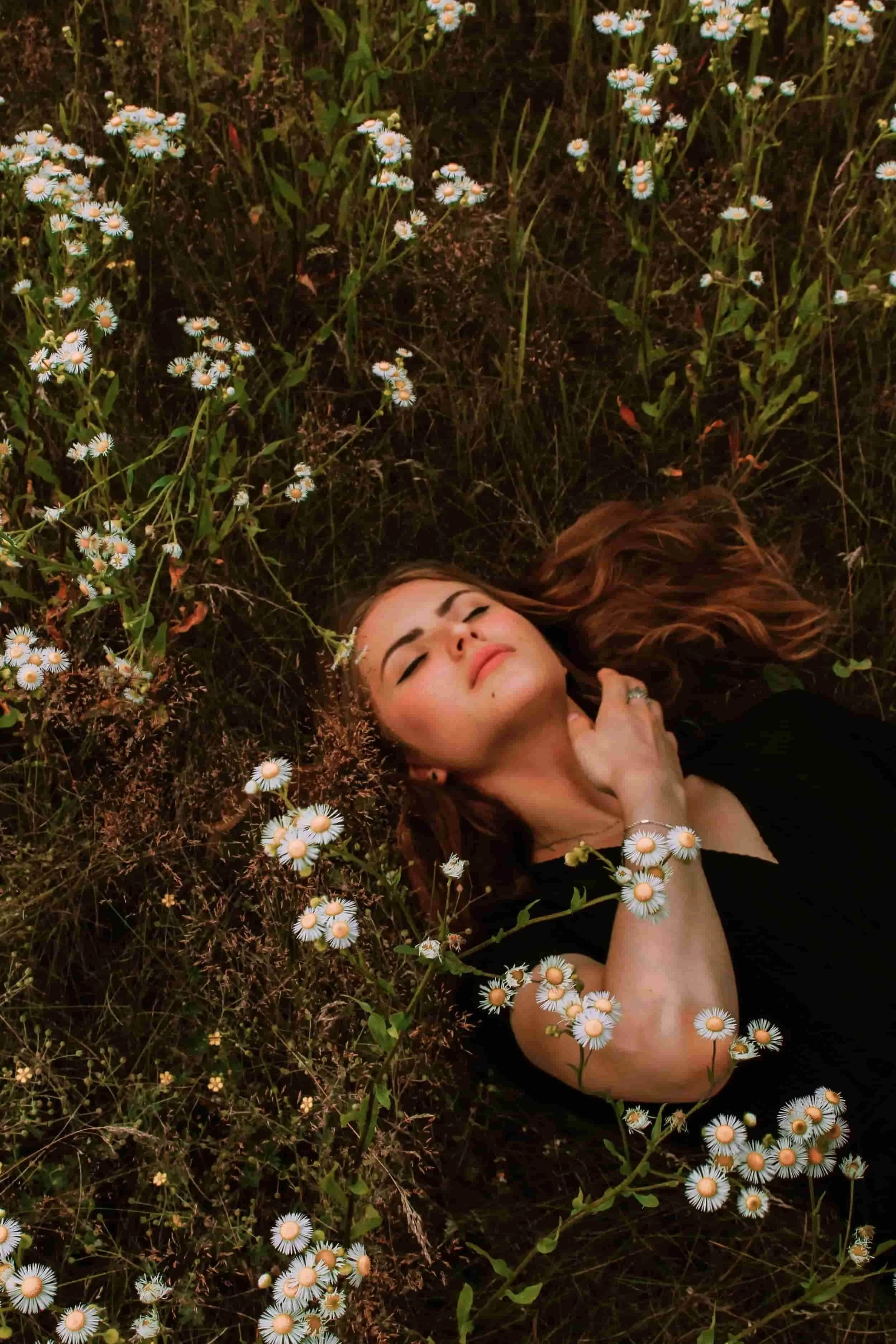 Woman resting quietly in a field of wildflowers, symbolizing comfort, reflection, and emotional healing through Christian grief counseling in Texas.