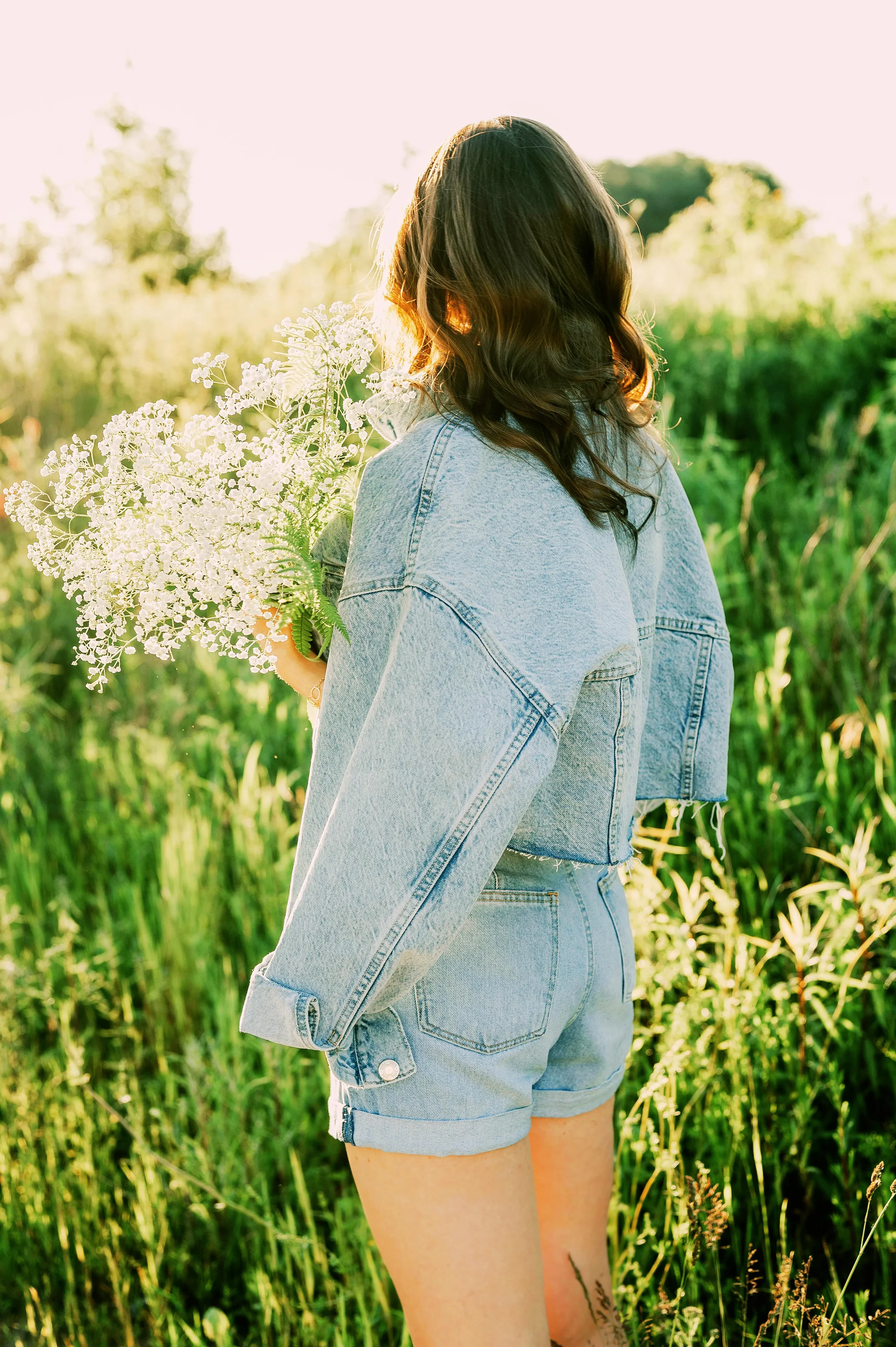 Woman holding wildflowers in soft morning light, symbolizing spiritual renewal, emotional healing, and faith-based Christian counseling for women and young adults in Texas.