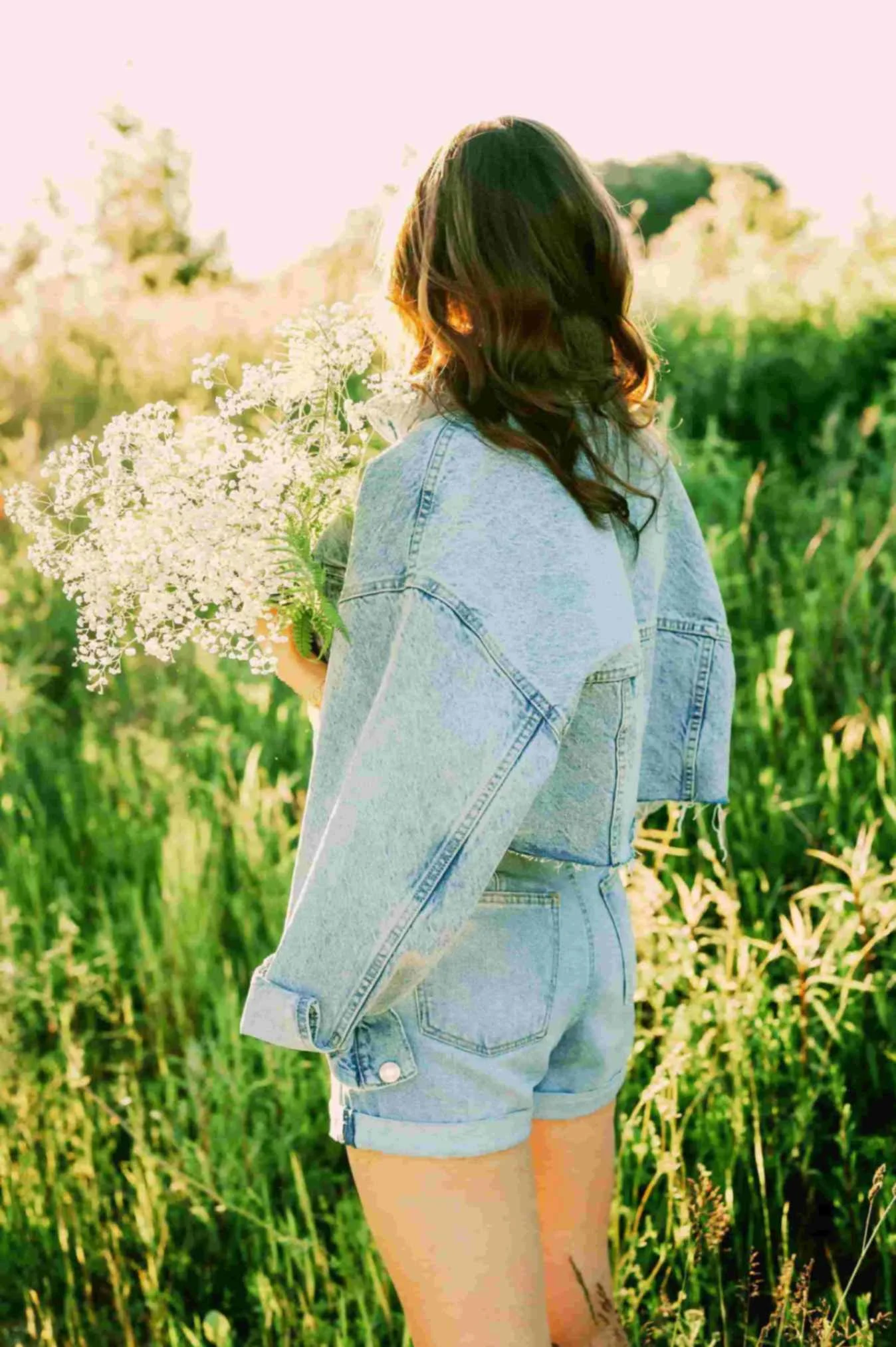 Woman holding wildflowers in soft morning light, symbolizing spiritual renewal, emotional healing, and faith-based Christian counseling for women and young adults in Texas.