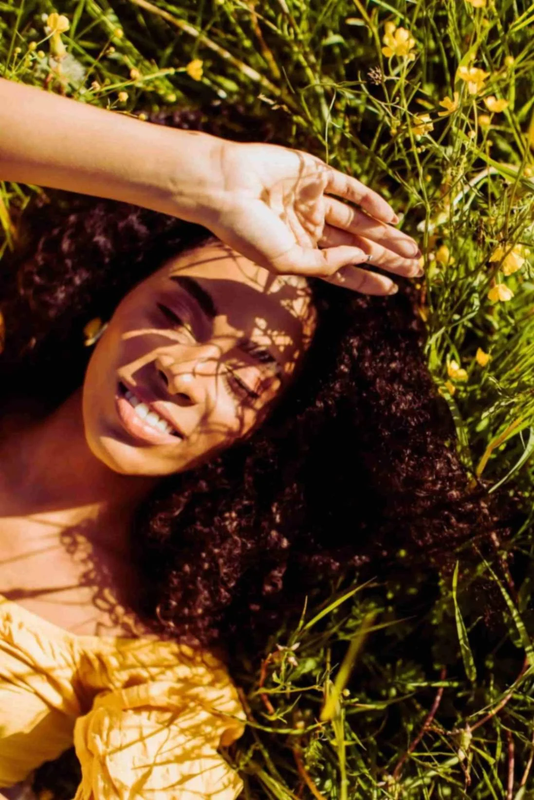 Woman resting in sunlit grass with eyes closed, symbolizing emotional healing, spiritual renewal, and faith-based Christian counseling for women and young adults in Texas.