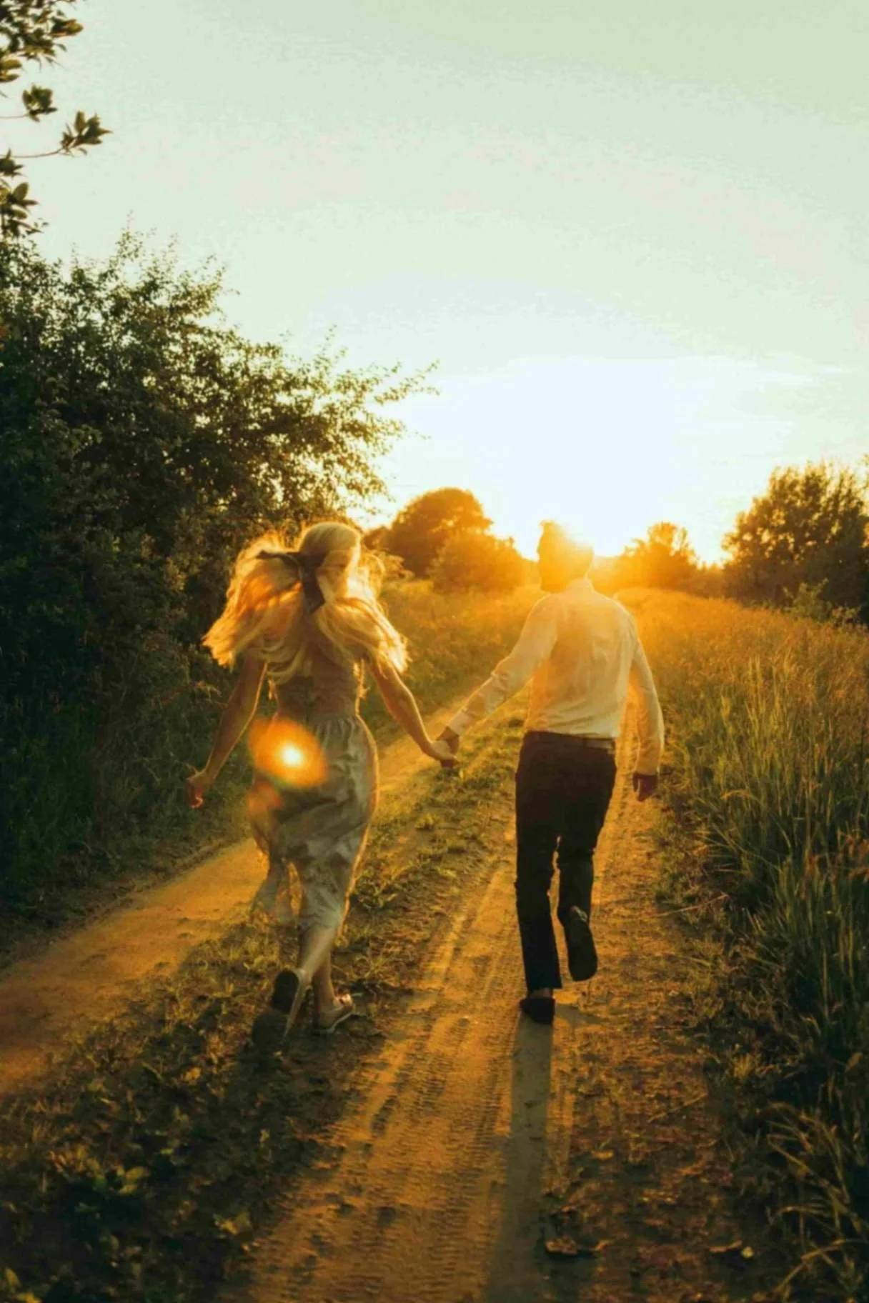 Couple holding hands while walking down a sunlit path, symbolizing secure attachment, relationship healing, and Christian counseling support for women and young adults in Texas.
