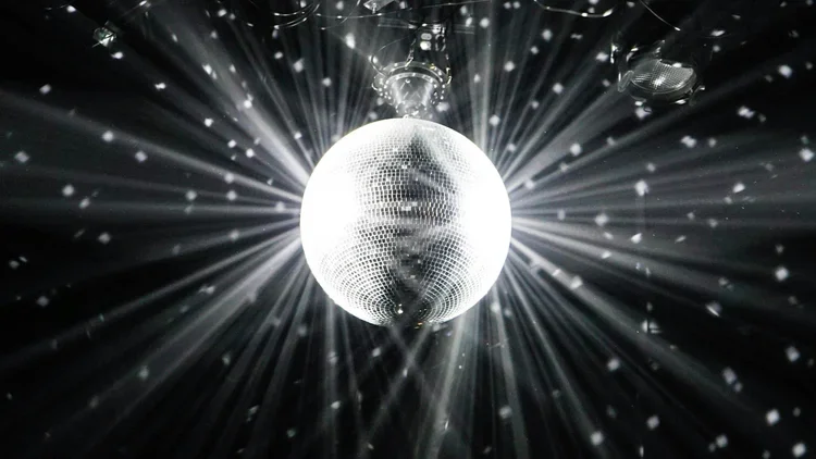 Sparkling spinning disco ball effect casting dazzling light patterns for an energetic and retro dance floor vibe.