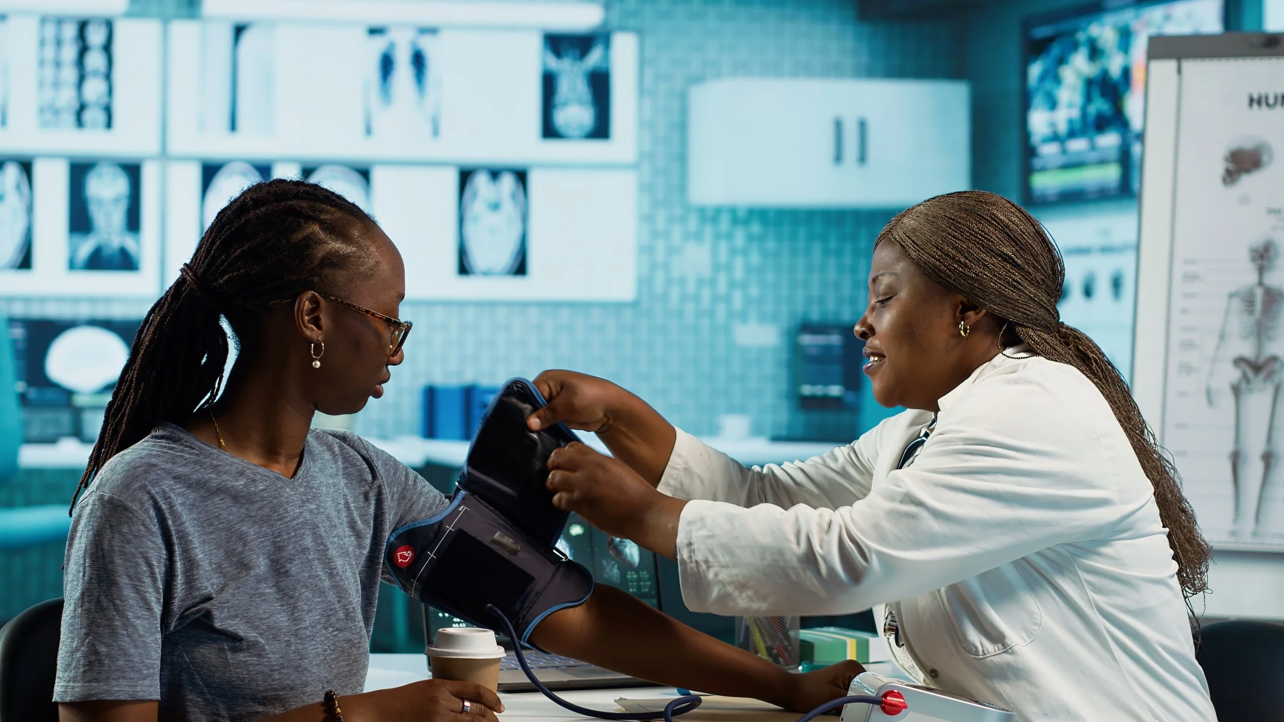 BIPOC woman having her blood pressure checked during a medical visit, representing hypertension care for women over 40.