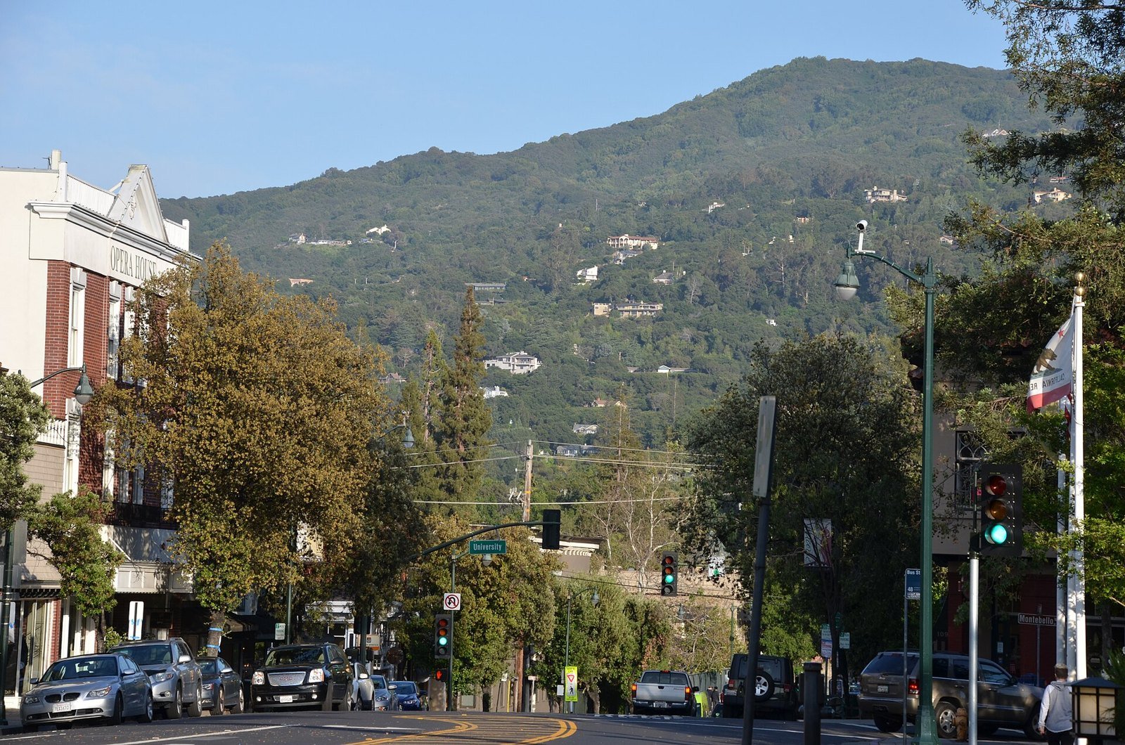 Shops and trees line Main Street in downtown Los Gatos, with the Santa Cruz Mountains rising in the distance.