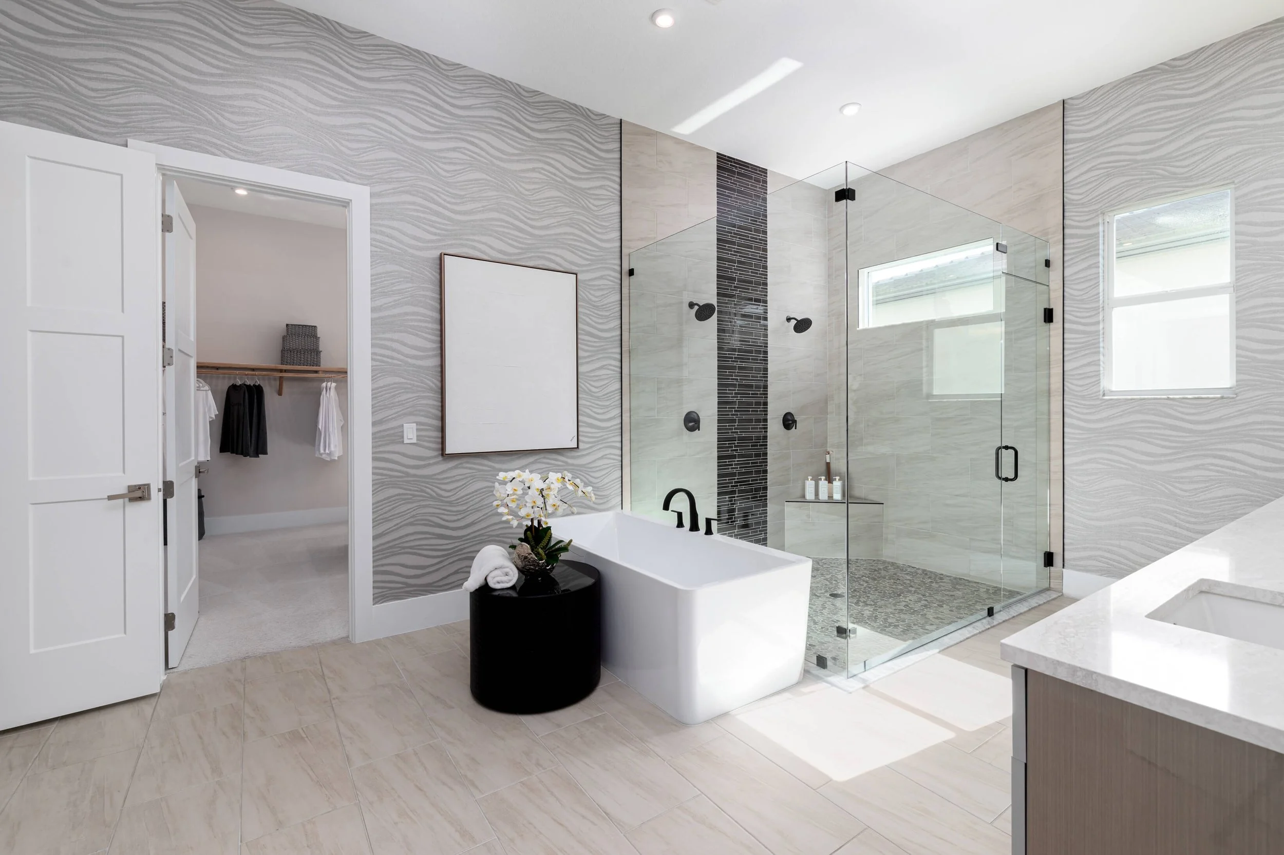 Modern bathroom with walk-in shower, bathtub, and walk-in closet