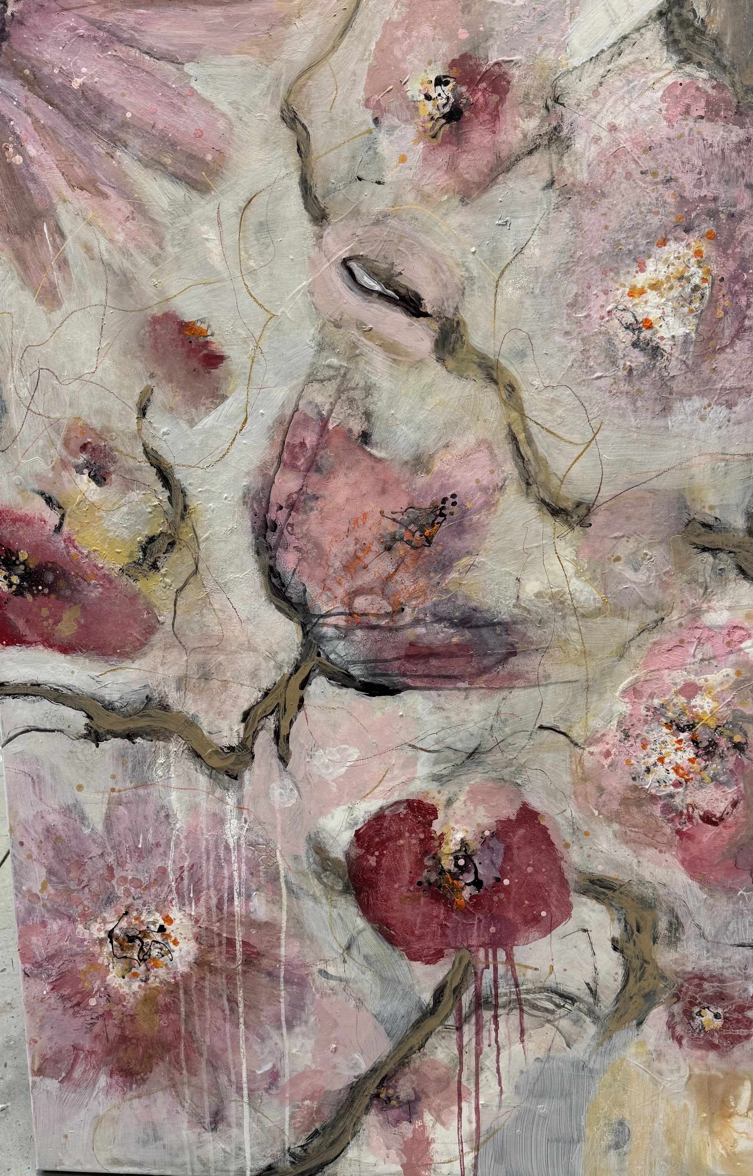 Abstrakt maleri med en kvinnelig ansikt i midten, omgitt av blomster eller pæreformer i rosa, rødt og beige nyanser, med gule, svarte og oransje detaljer.