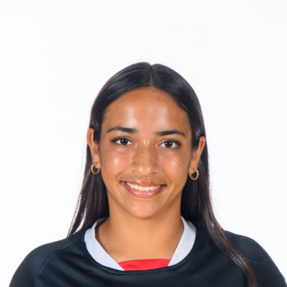 Young woman smiling with straight black hair, gold hoop earrings, wearing a black sports jersey over a white shirt with a red collar, against a white background.