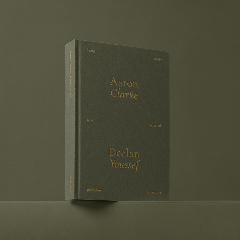A dark green hardcover book standing upright on a surface with a plain olive-green background. The cover features gold text with the names Aaron Clarke and Declan Youssef, along with other smaller text.
