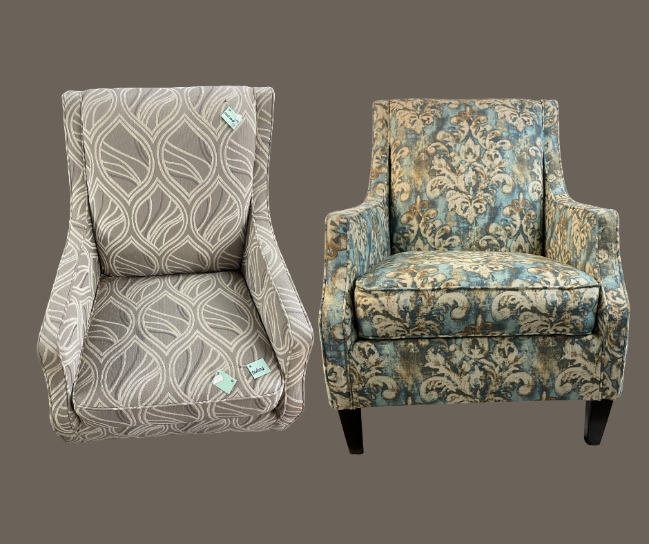 Two upholstered armchairs with patterned fabric, one beige with a leaf design and one blue with a floral design, set against a plain background.