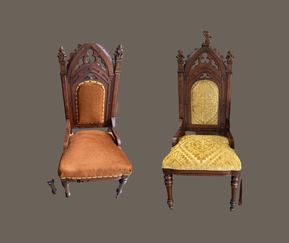 Two antique wooden chairs with ornate gothic-style high backs and upholstered seats; the left chair has orange-brown fabric, and the right has gold fabric with a floral pattern.