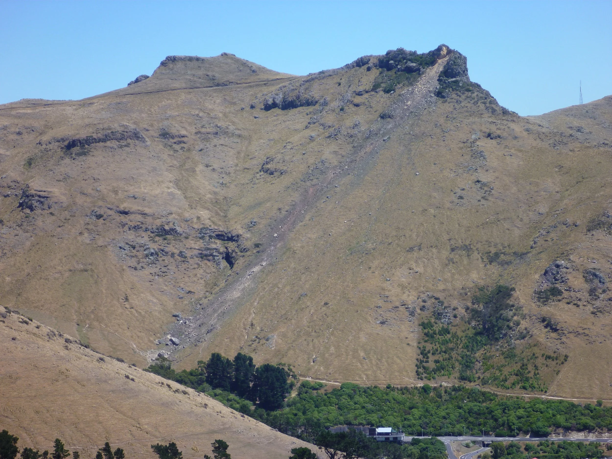 A mountain clearly showing a pathway of rockfall from the peak.