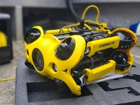 Yellow underwater drone labeled 'Chasing M2' on a foam pad.