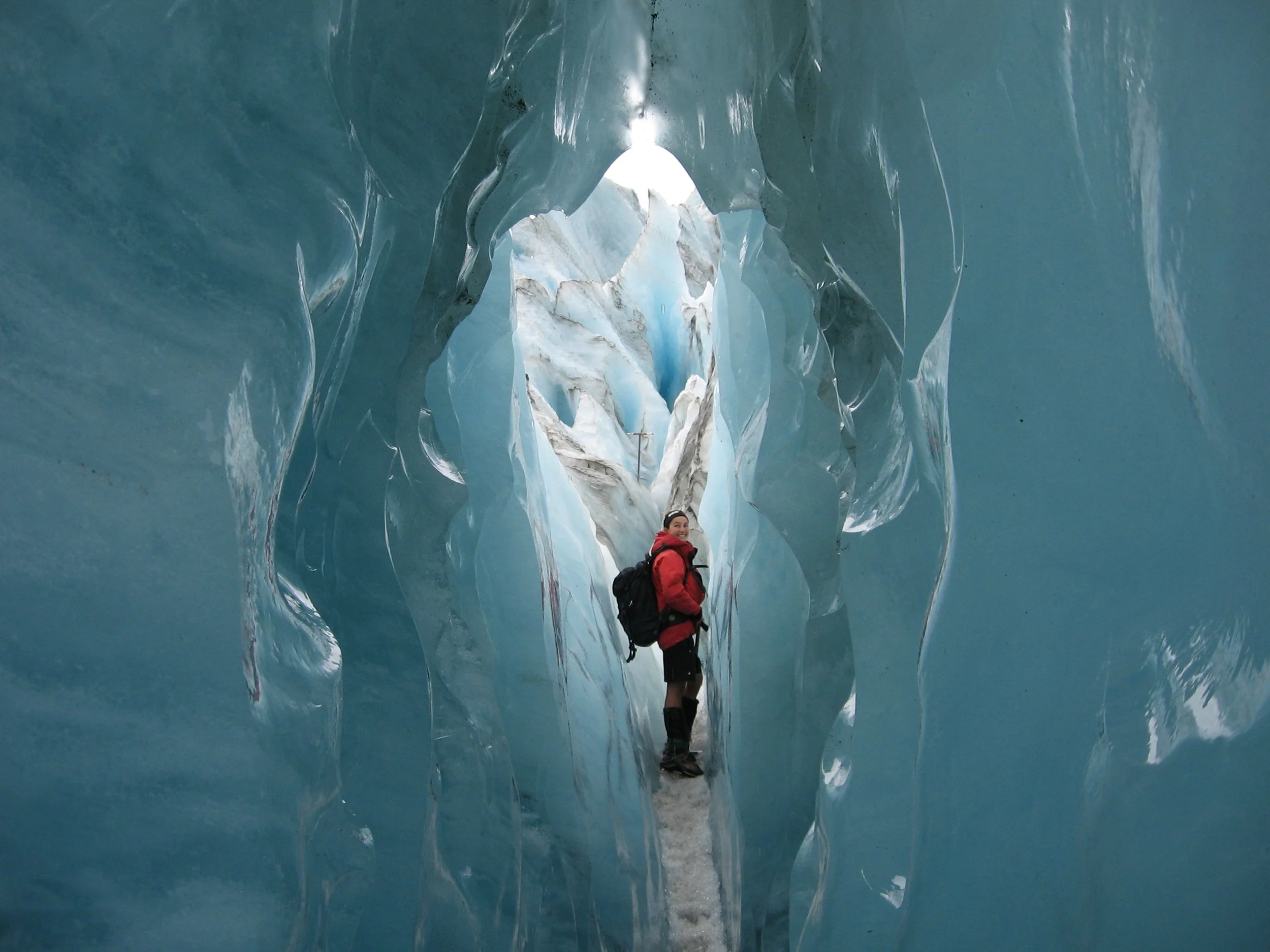 A person standing in a glacier cave.