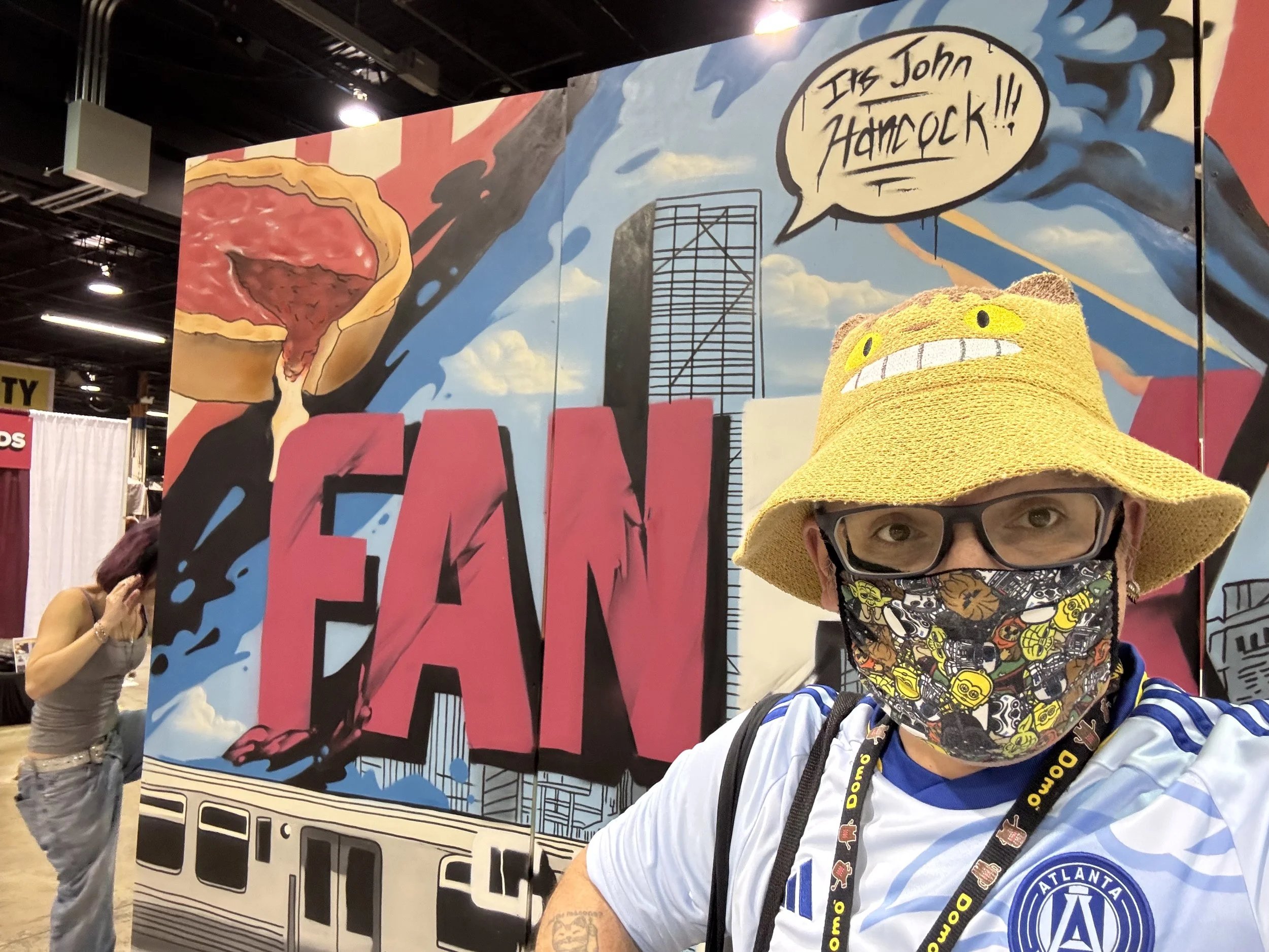 CatBusRuss infront of a fun, Chicago-themed mural for Fan Expo