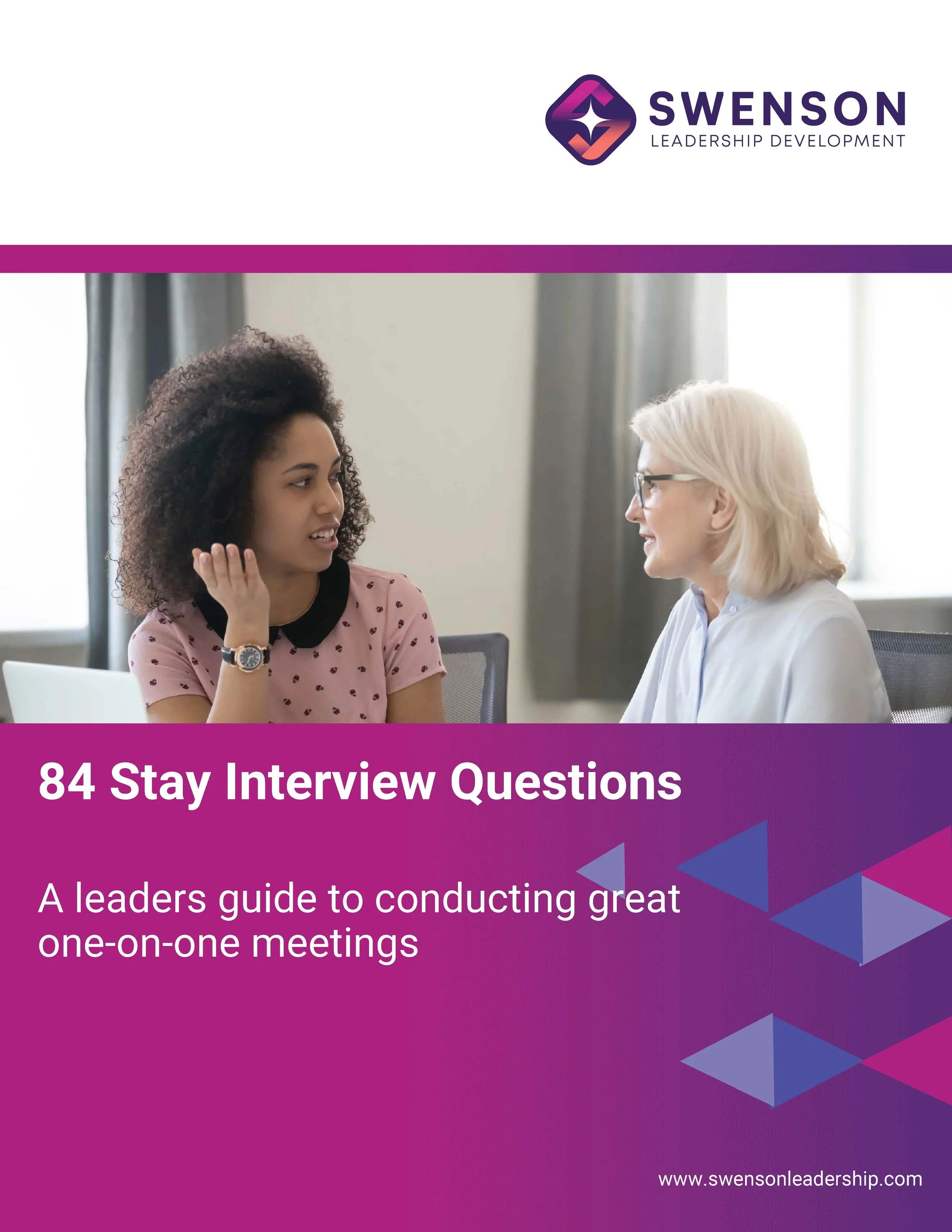 Cover of a guide titled '84 Stay Interview Questions' with a subtitle 'A leader's guide to conducting great one-on-one meetings'. The cover features an image of two women sitting at a table, one with curly hair and a pink shirt, and the other with straight blonde hair, glasses, and a white shirt, engaged in conversation.