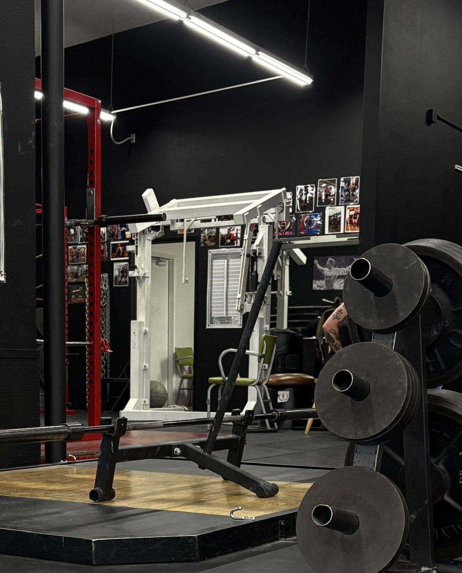 Squat rack, mono-lift rack, weight plates, and strength equipment at Downing's Gym.