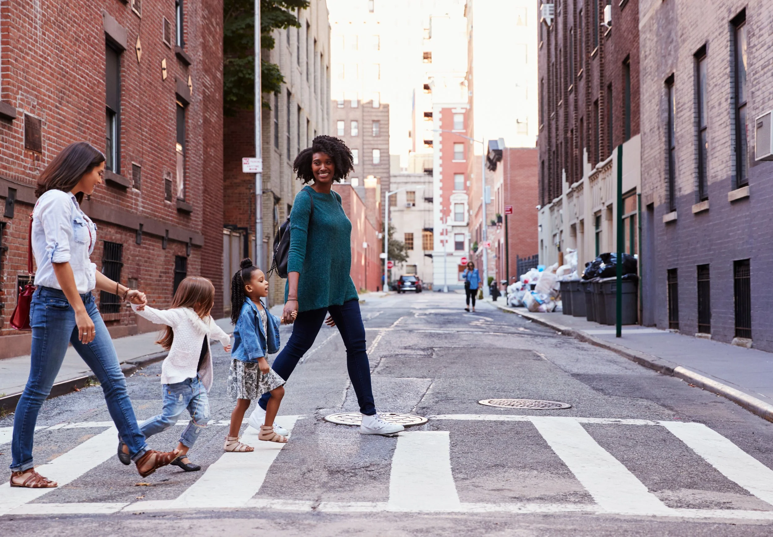 Two nannies walking with little kids in NYC.