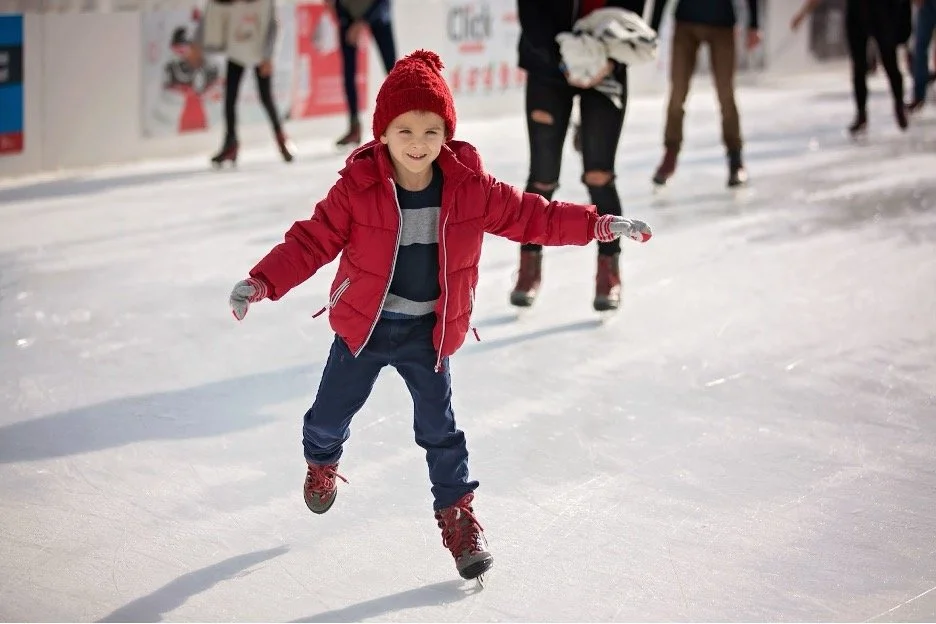 A child skating in a red jacket.