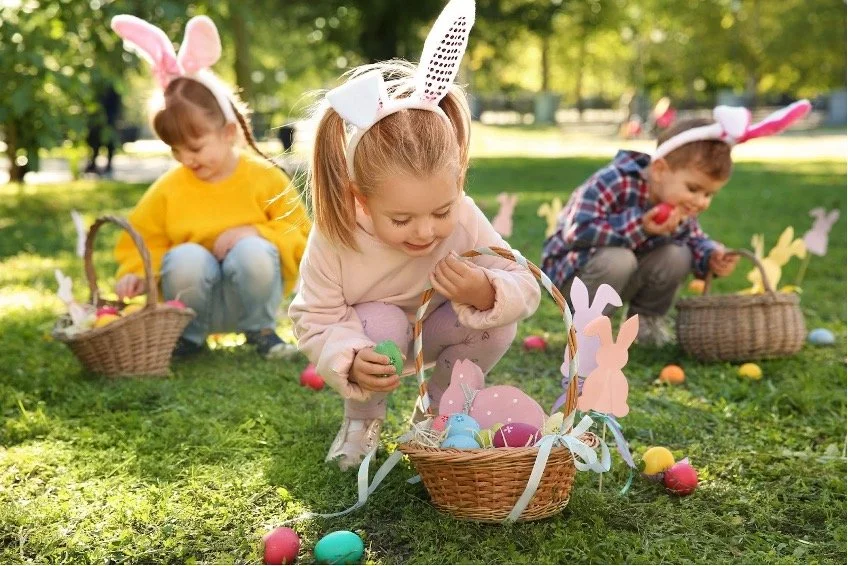 A group of kids on an Easter Egg Hunt in the grass.