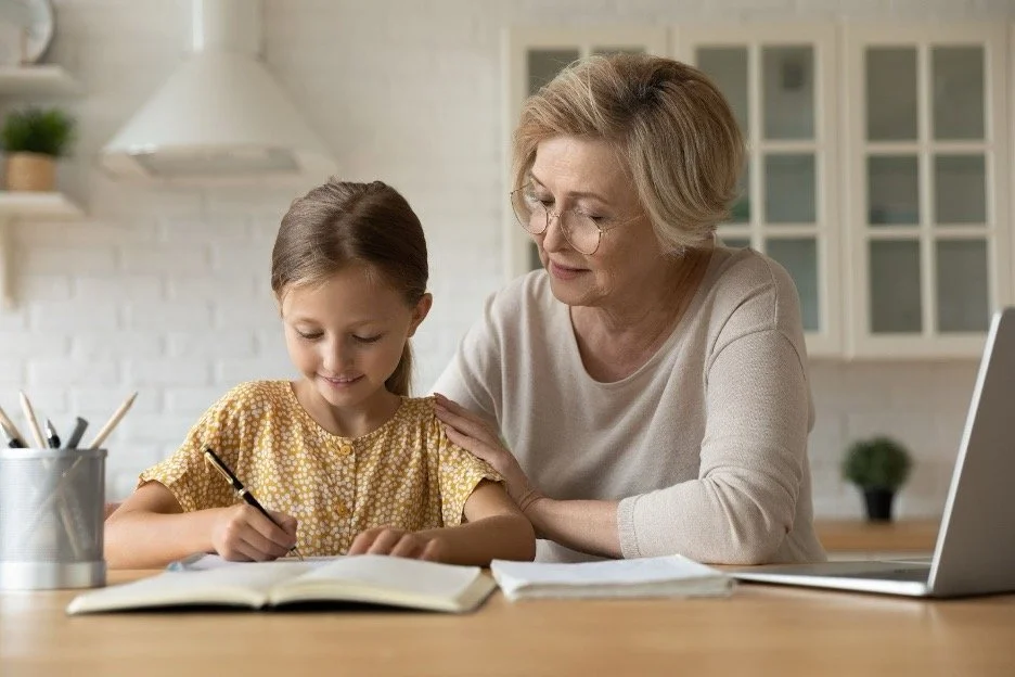 A nanny helping a child with homework.