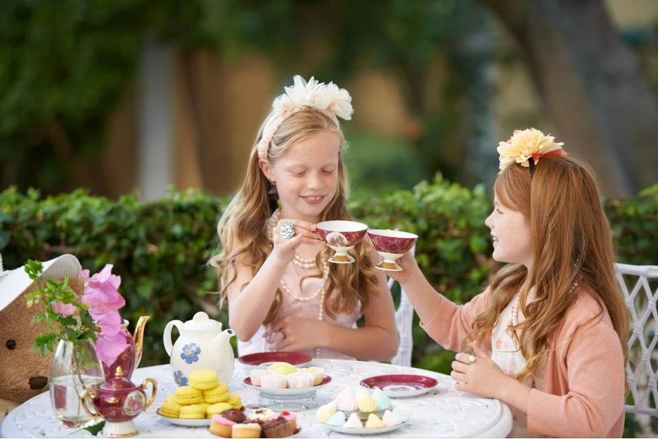 Two girls at a tea party outside.