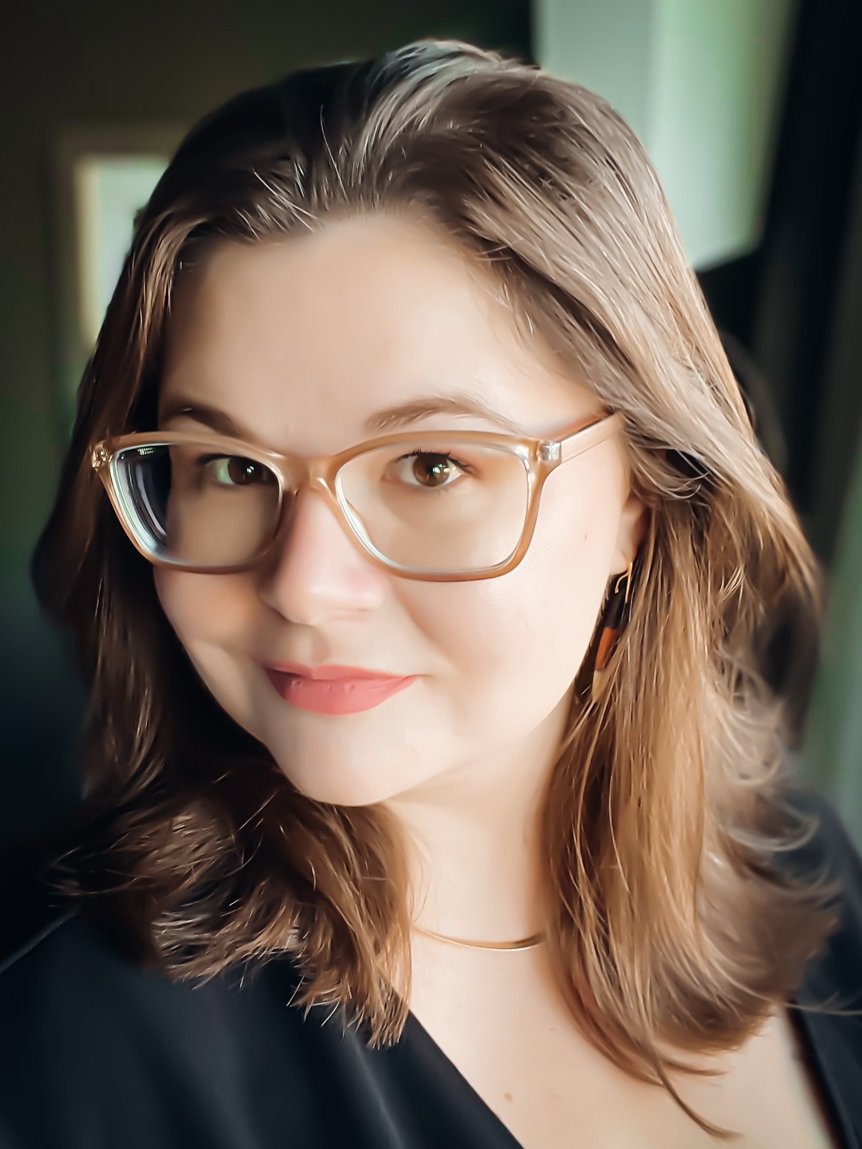 Headshot of Mindy Wara - 30 year-old woman smiling with brown hair and eyes, glasses, and a gold necklace