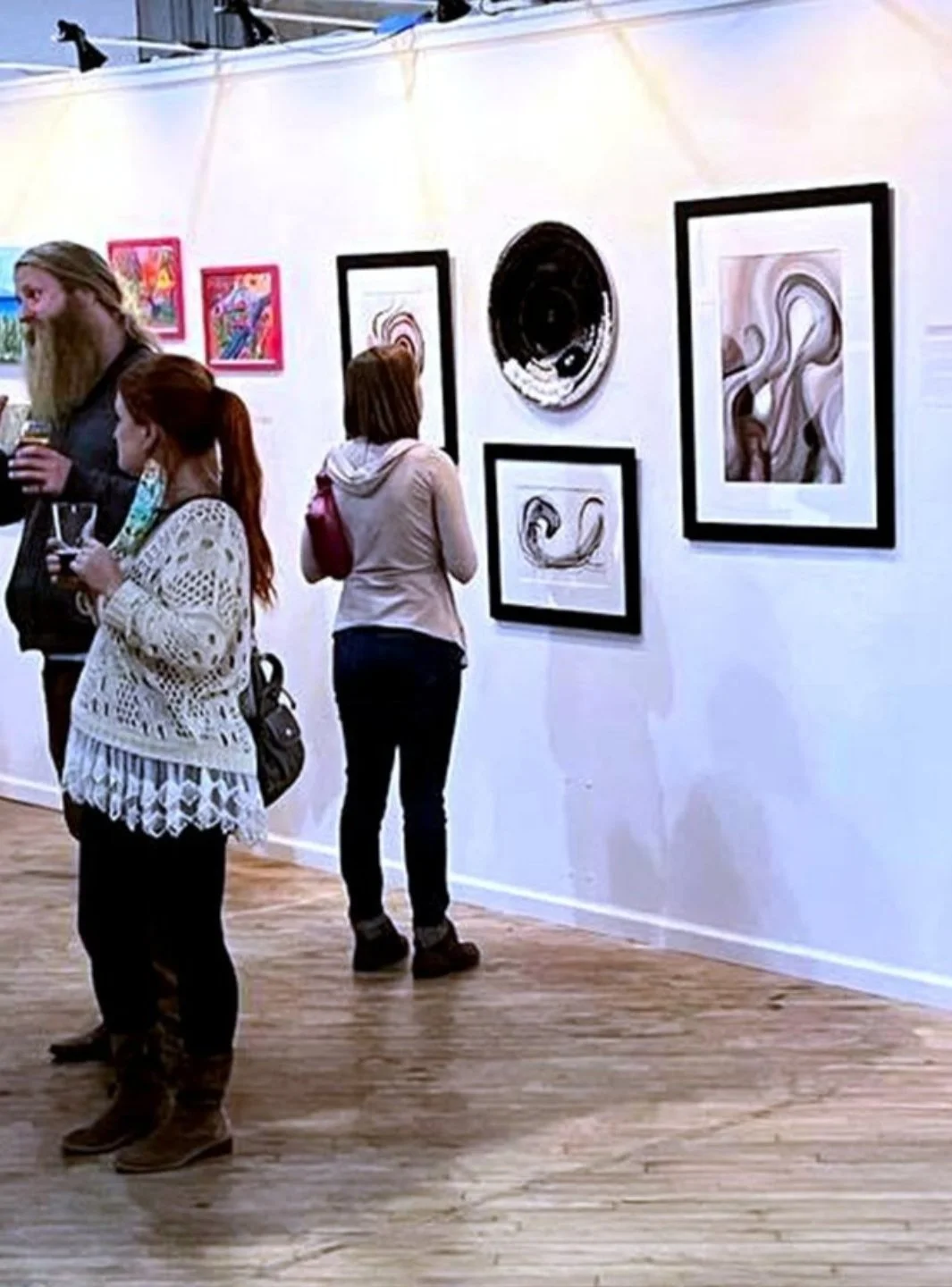 photo of a woman looking at The Postpartum Collection on display at an art exhibition