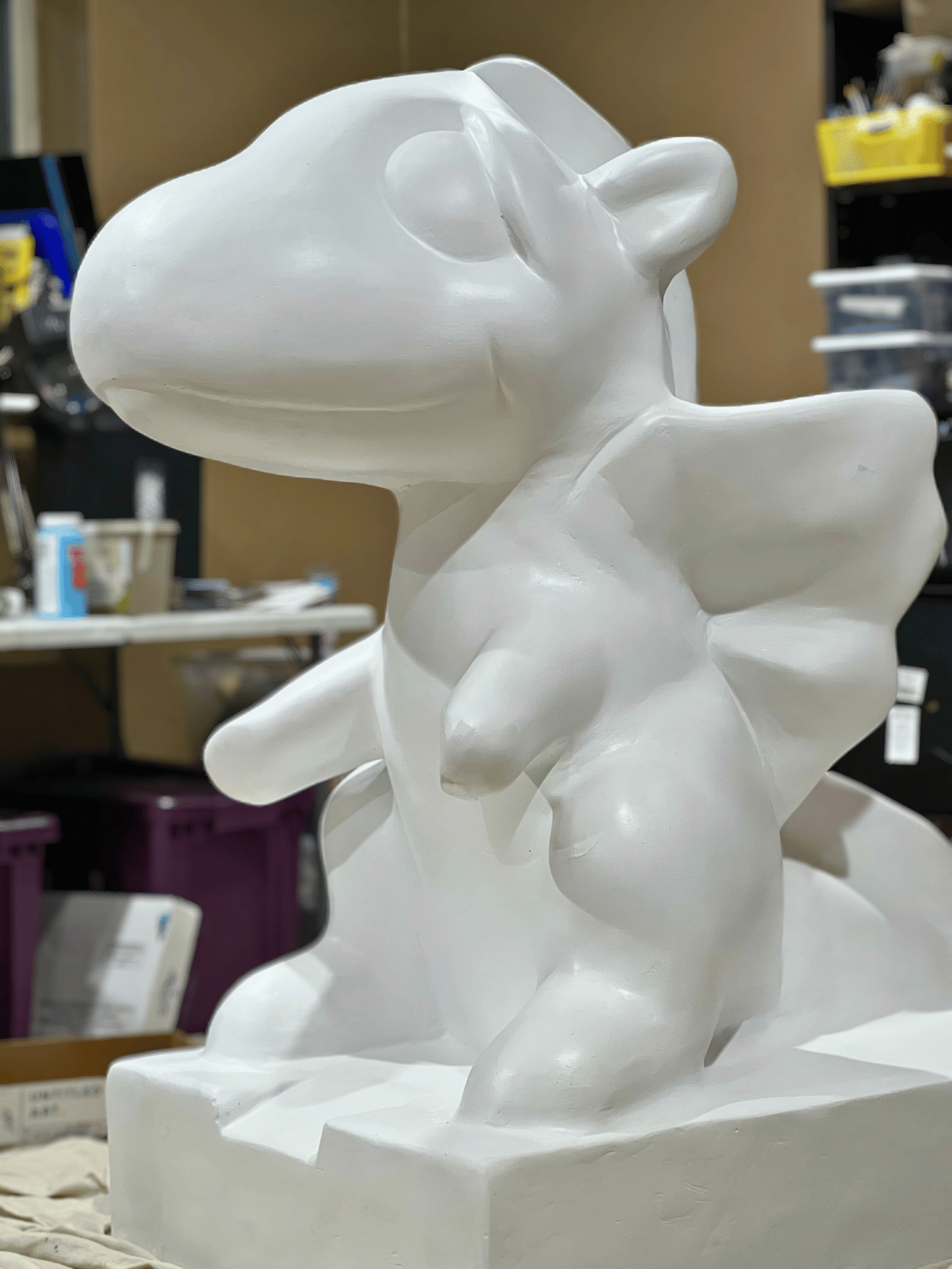 White fiberglass dragon statue in an art studio