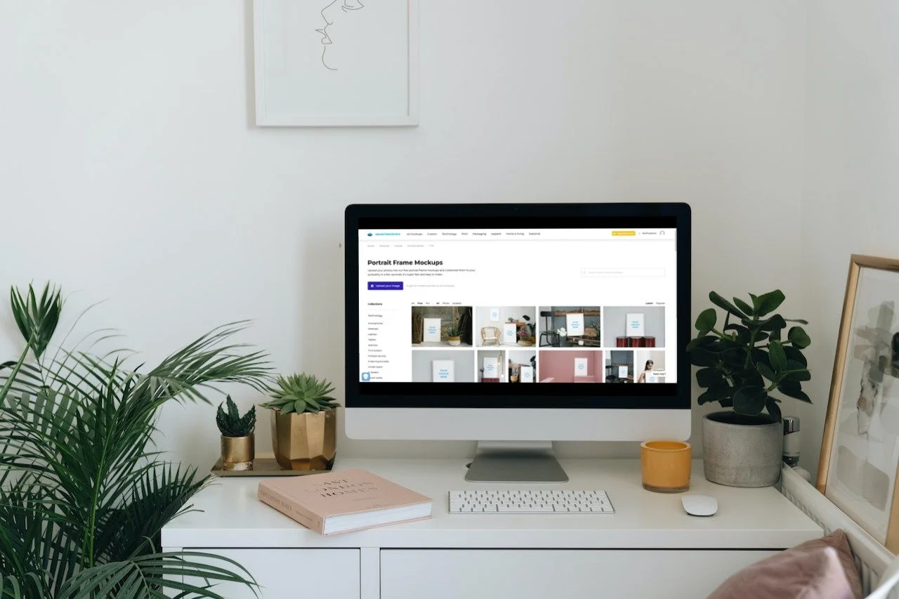 White desk with desktop computer and succulents. Smartmockup.com is on the screen.