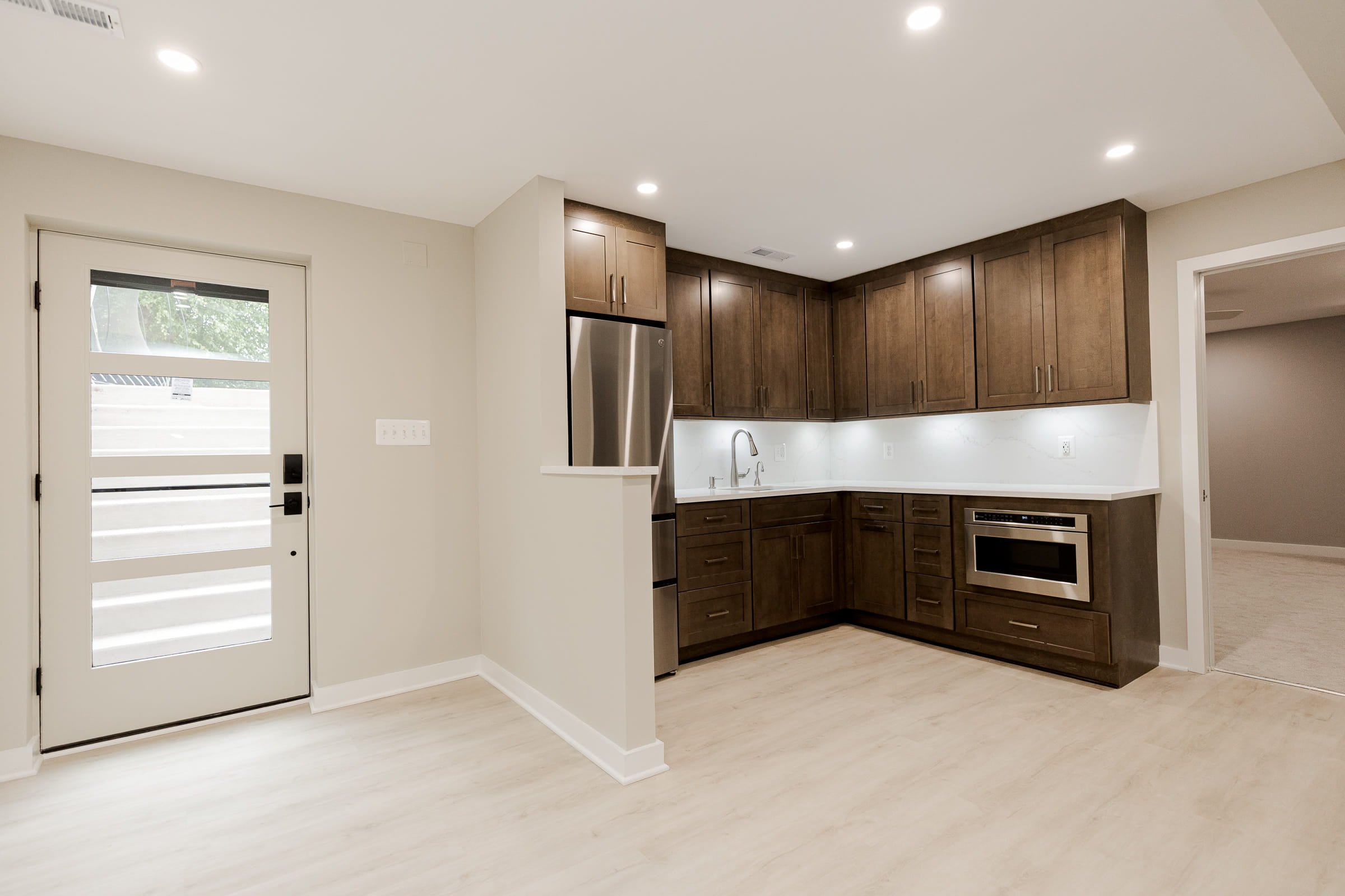 basement finishing Langley, basement renovation contractor Langley, basement finishing Silverthistle Ct, basement kitchenette remodel, Fabuwood Galaxy Mocha basement cabinets, basement walkout entrance addition, Studio Tifton luxury vinyl plank basem