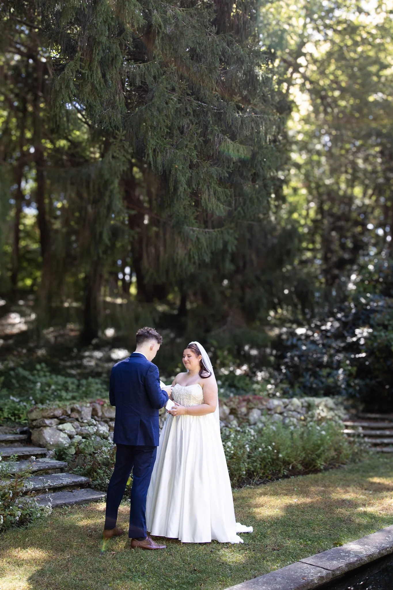 Beautiful garden ceremony site with couple sharing private vows. Golden glow and light for the couple in Cape Cod, MA.