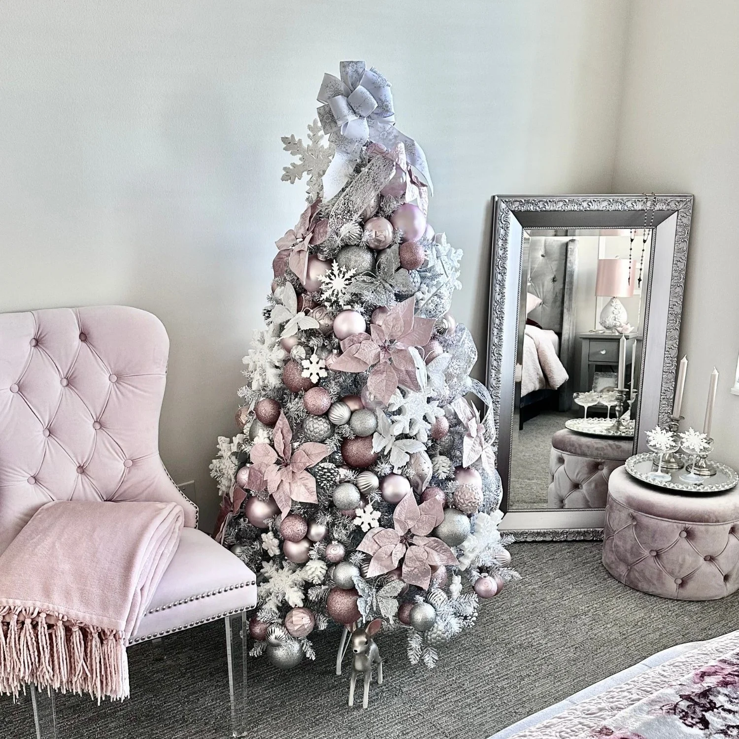 A beautifully decorated artificial Christmas tree styled with furniture and holiday accents, showcasing a polished, effortless holiday look.