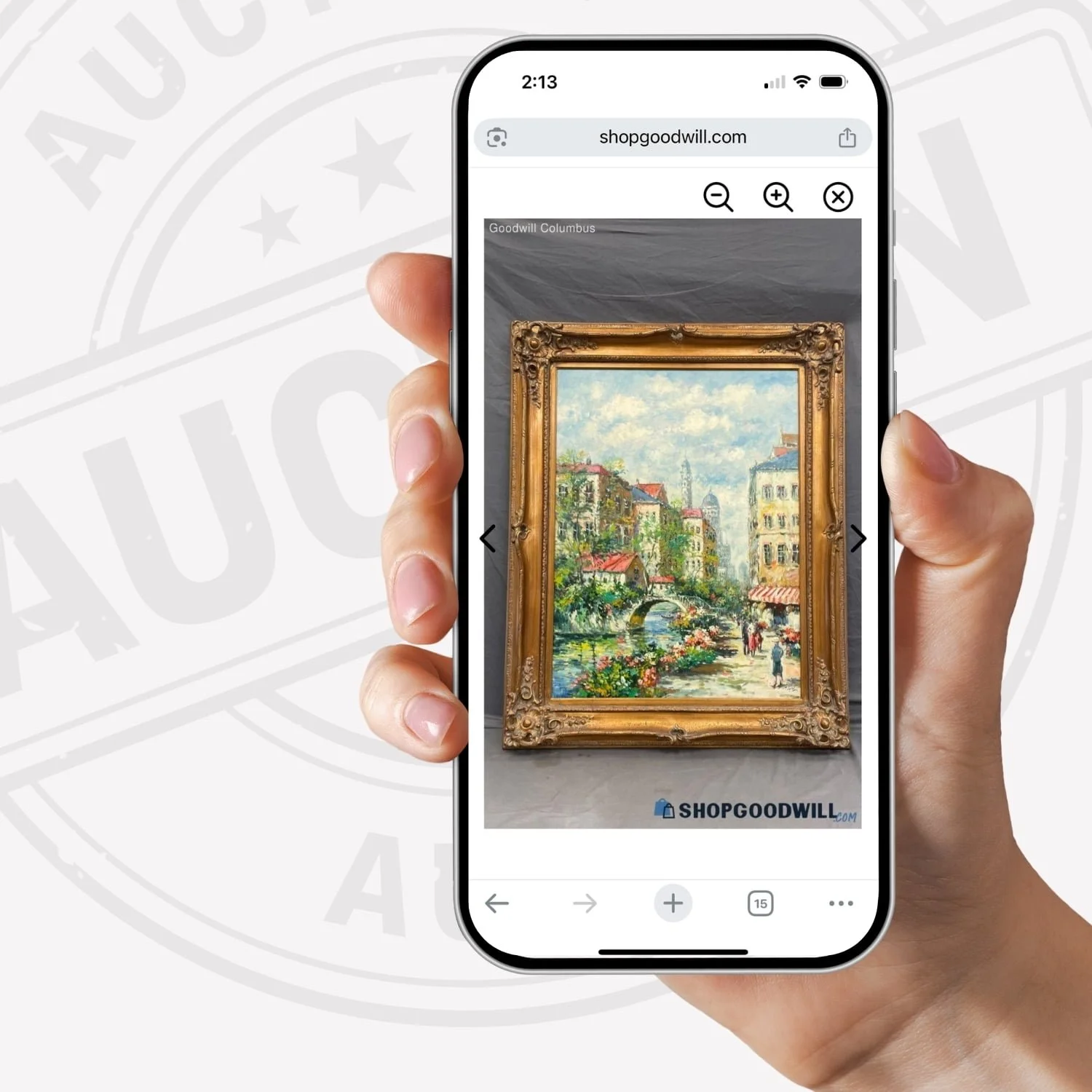 A hand holding a smartphone displaying a Goodwill online auction listing featuring a large, ornate gilded picture frame.