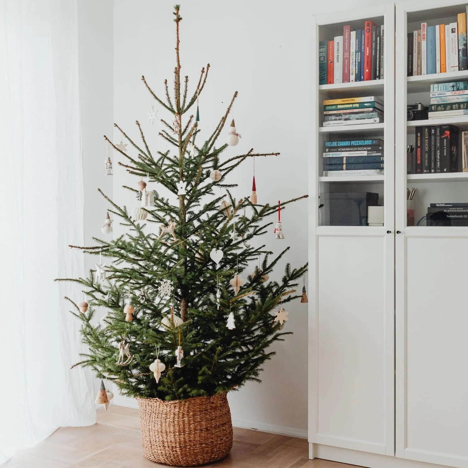 A simply decorated real Christmas tree with minimal ornaments, showcasing the natural beauty and texture of the branches.