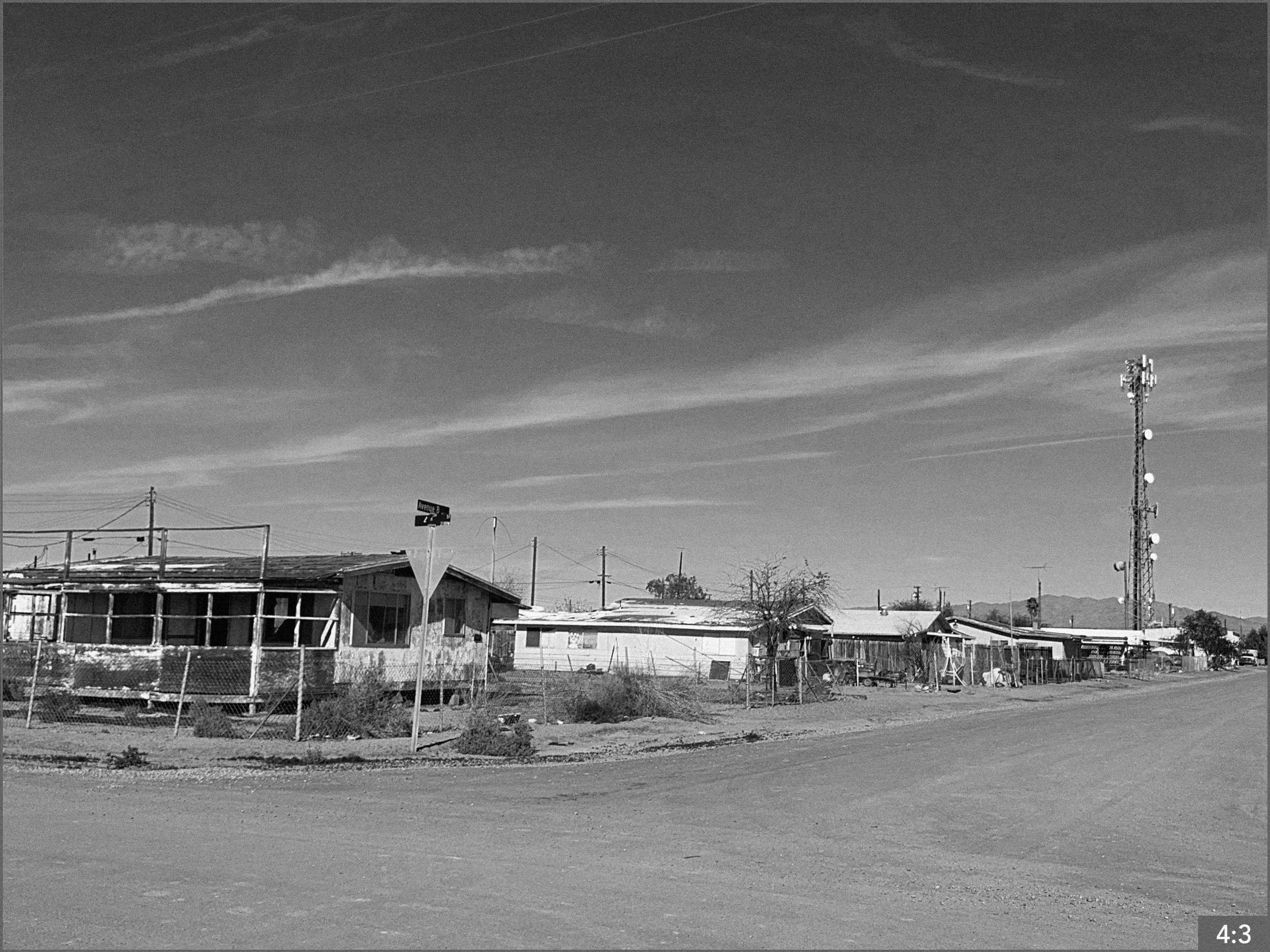 22. Bombay Beach Salton Sea 11:00 am 6. LONG SHOT: father and daughter stand in the middle of the street looking at one another.